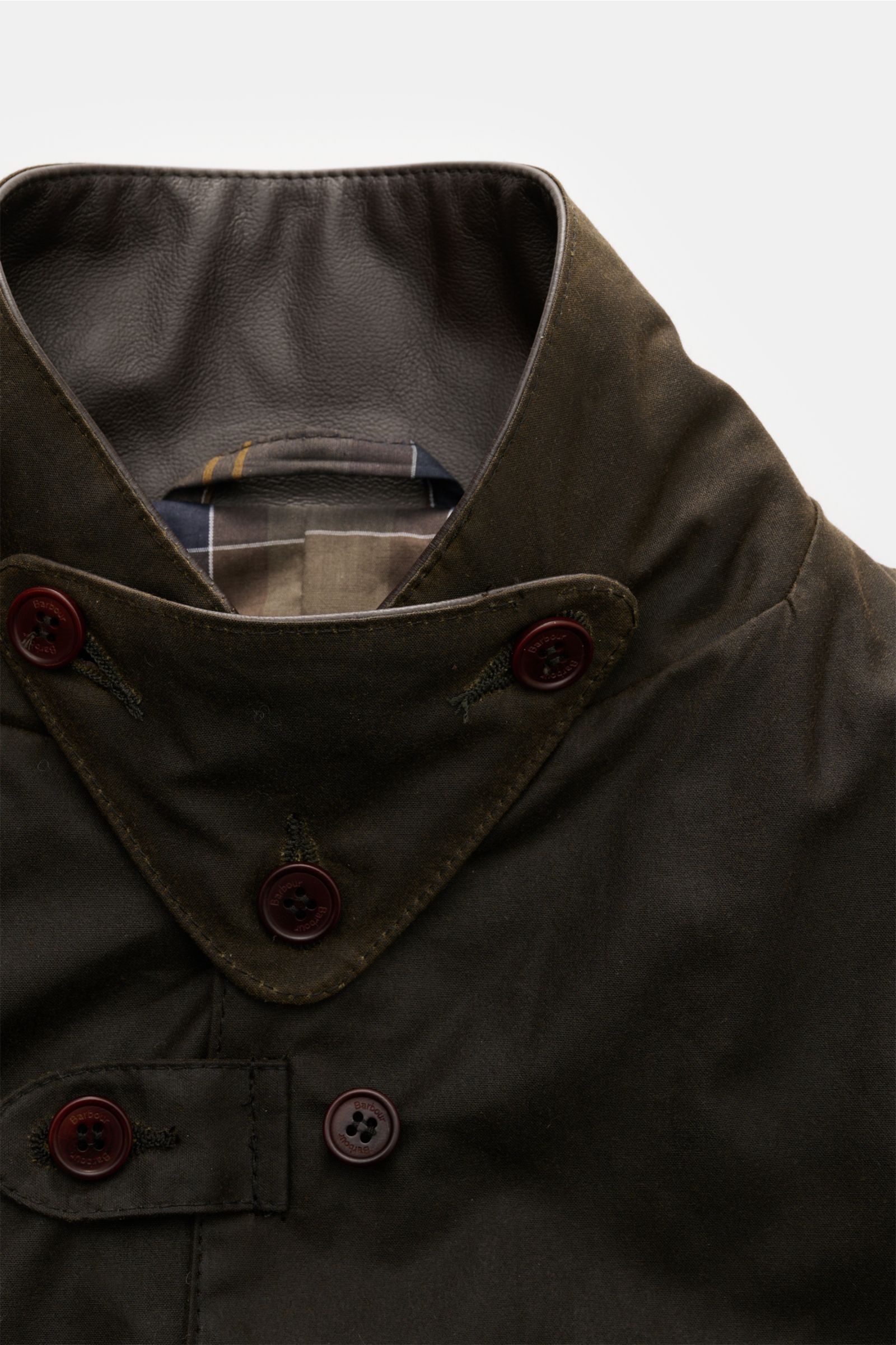 Barbour Wachsjacke 'Becan' dark olive, Nahaufnahme von Kragen mit Lederdetails, Knopfleiste, gewachste Baumwolle, Tartan-Futter sichtbar