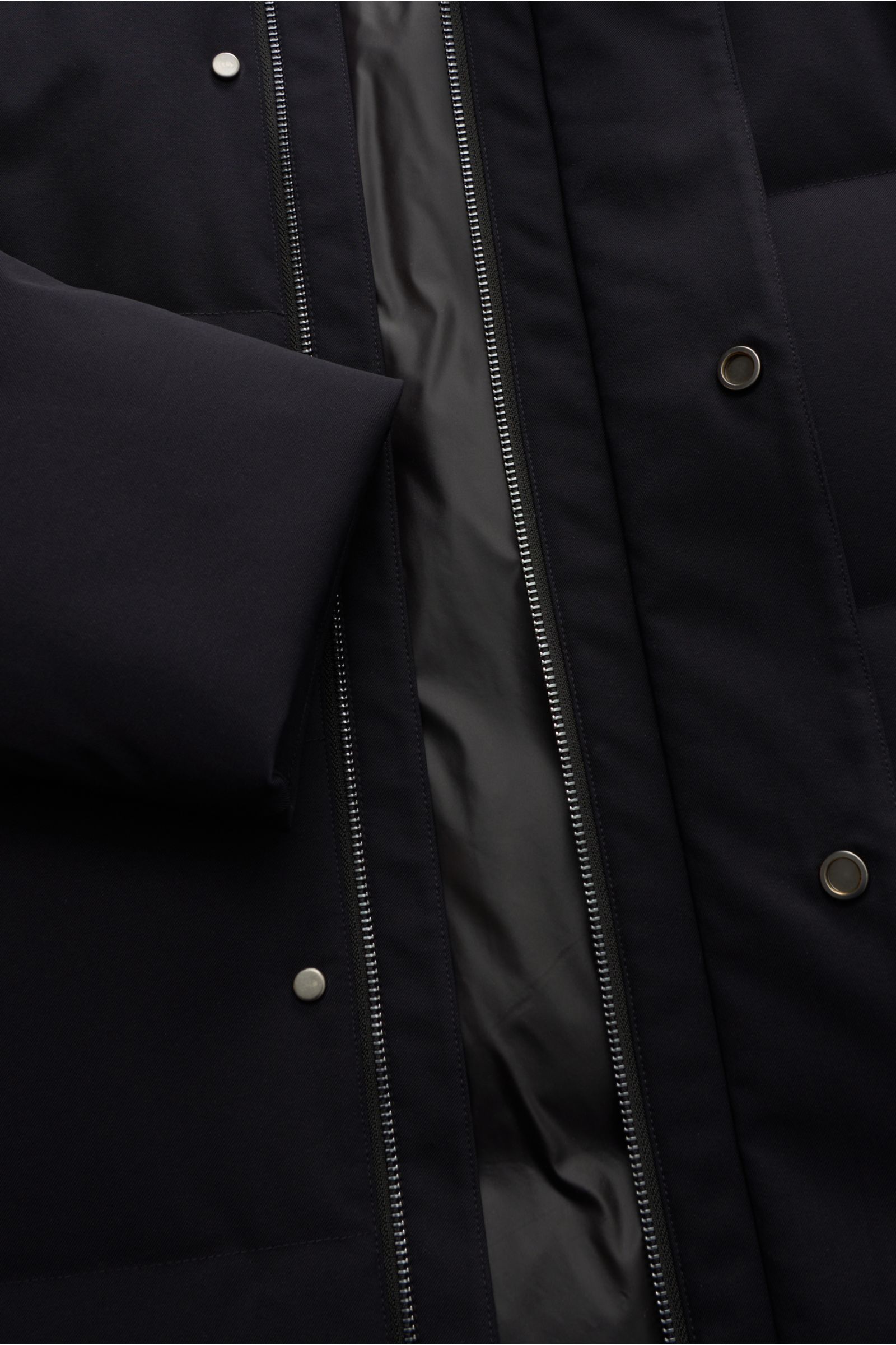 Close-up front view of the Montecore Down coat dark navy showing high-quality microfibre, slightly robust touch, wind and water repellent, breathable fabric, duck down lining, regular fit, robust two-way zip, storm flap with snap buttons, high fastening c