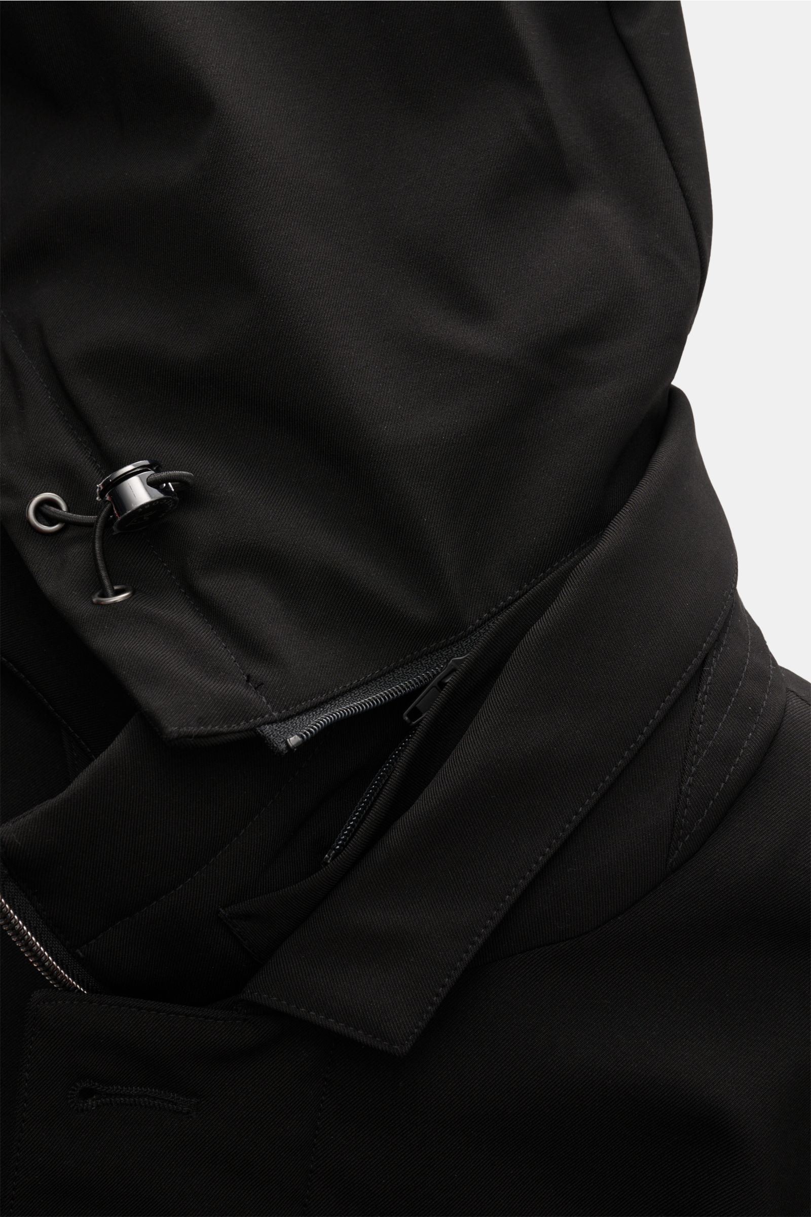 Montecore Daunen-Kurzmantel schwarz aus wind- und wasserabweisendem AeroTwill, Detailaufnahme von Kapuze und Kragen mit Reißverschluss.