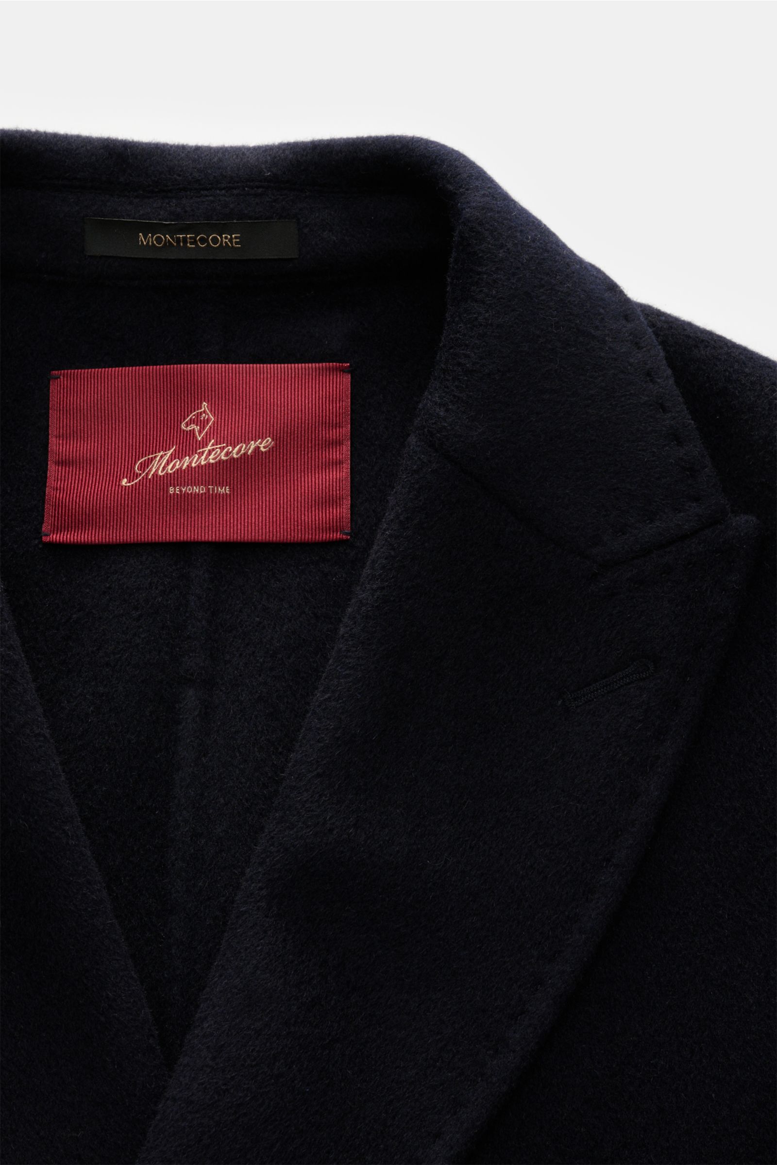 Close-up front view of Montecore Cashmere Cabanjacke navy, a classic slim fit coat made of pure cashmere with soft texture, featuring a typical double-breasted three-button style, pointed lapels, slanted welt pockets, buttoned sleeve cuffs, unlined interi