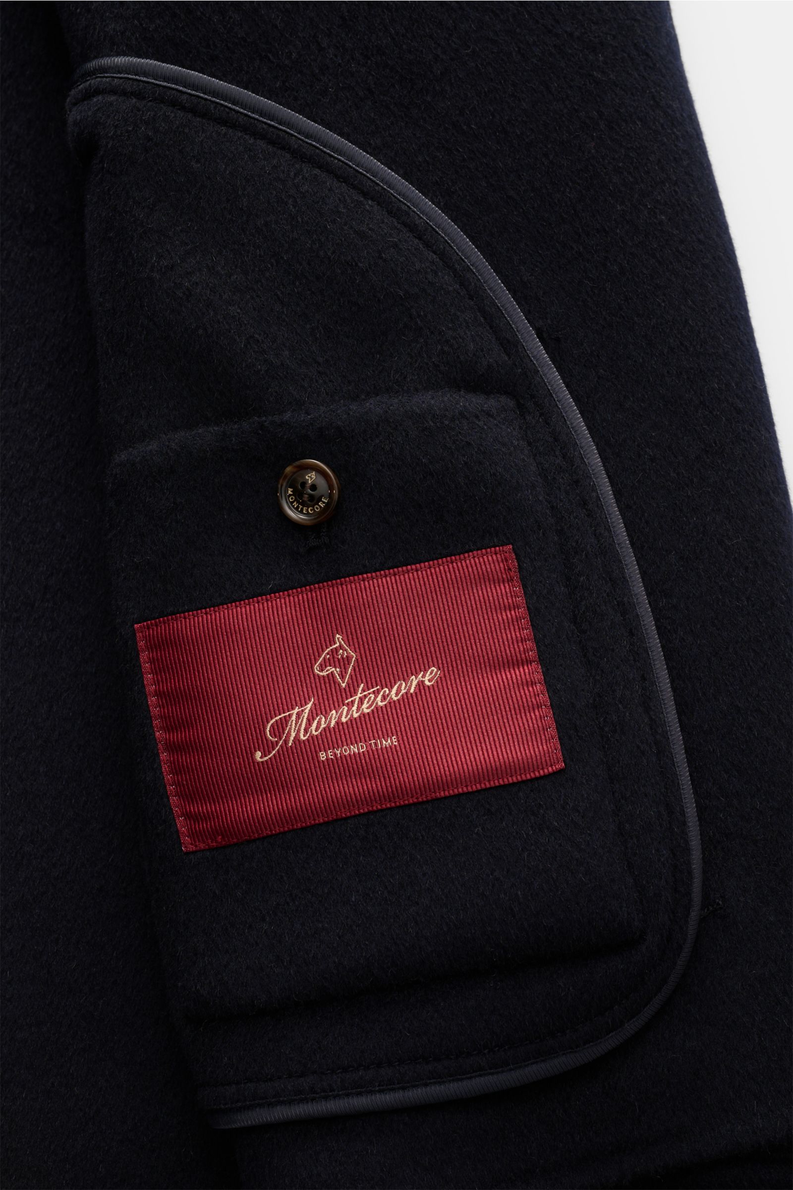 Close-up interior view of the Montecore Cashmere jacket navy showing the unlined pocket with a red Montecore label and button detail, highlighting the pure cashmere soft feel and slim fit design.

Description: Classic lightweight jacket: MONTECORE underst
