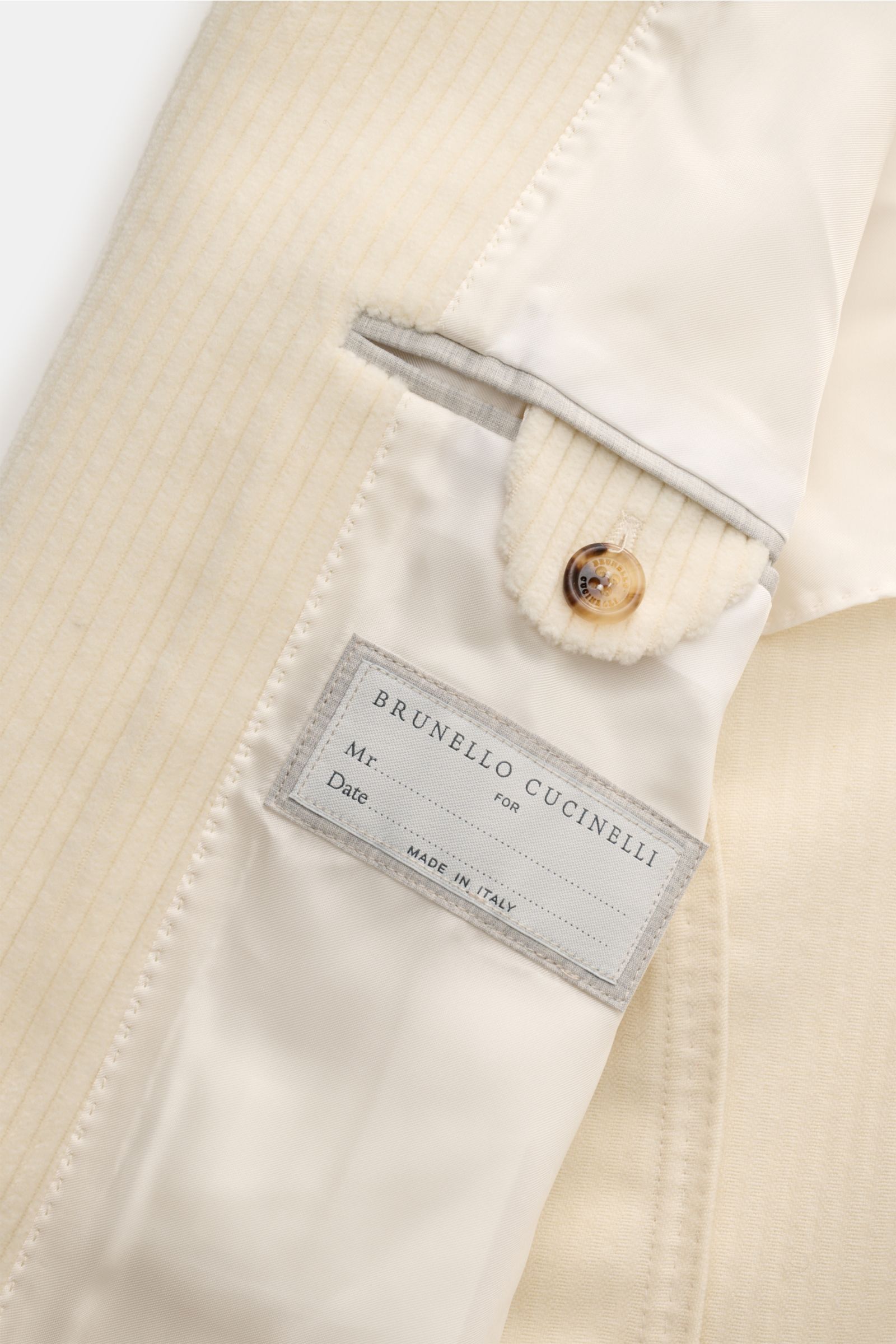 Close-up of the inner lining and label of the Brunello Cucinelli Cashmere Cordjacke creme, showing detailed stitching and button.

Description: Der zeitlose Stil dieser Cordjacke im Sakko-Design erhält von BRUNELLO CUCINELLI ein luxuriöses Upgrade durc