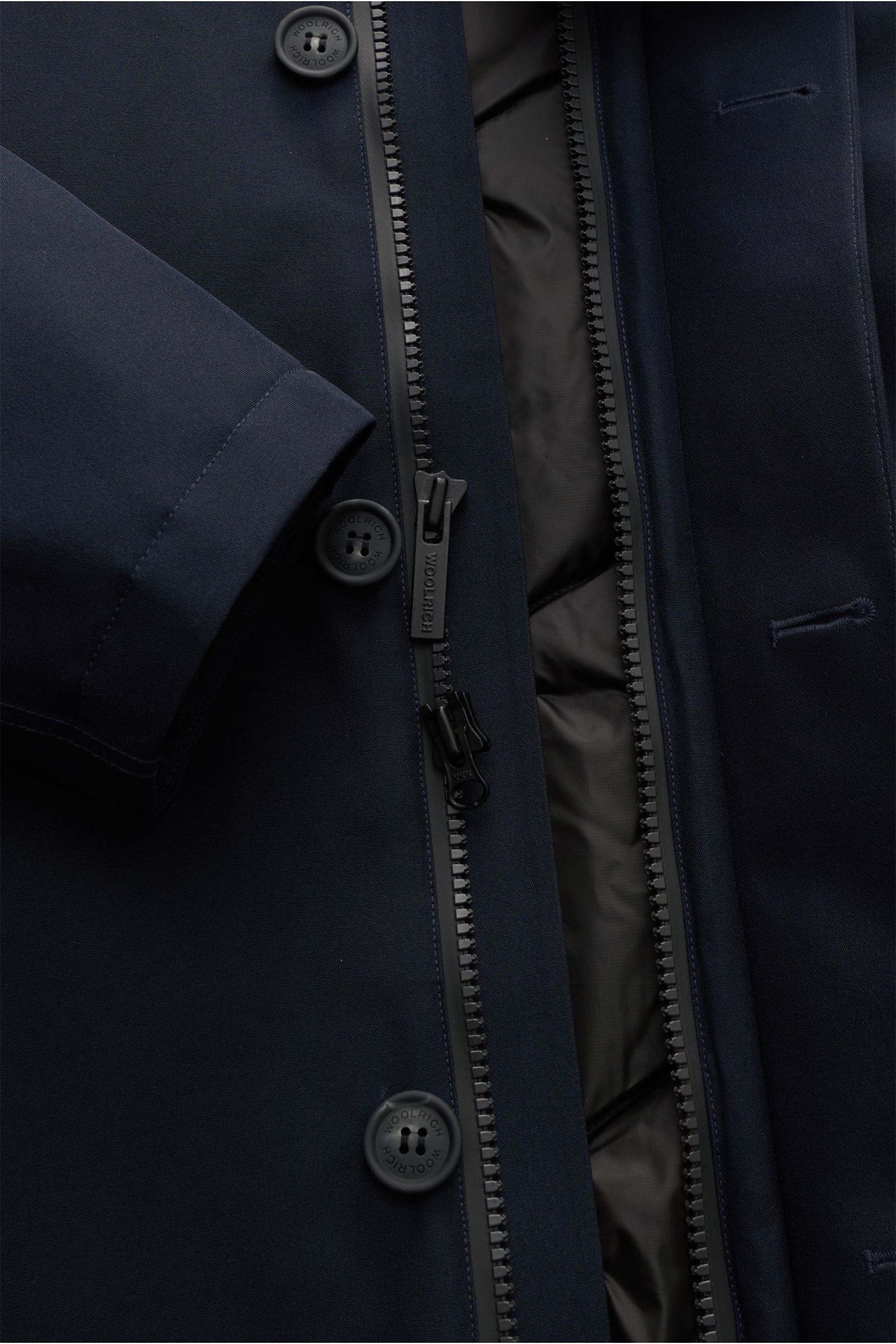 Close-up front view of the Woolrich Daunenjacke dark navy showing functional microfiber (GORE-TEX), wind- and waterproof fabric, breathable, warm down filling, taped seams, slim fit, robust two-way zipper, wind flap with buttons, high collar with hood, ha
