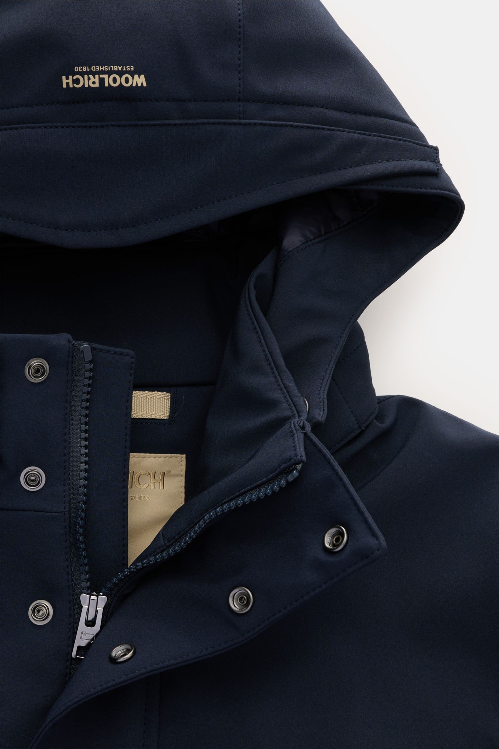 Close-up front view of Woolrich Softshell-Daunenparka schwarz hood and upper zipper area, showing smooth, elastic, water-repellent microfiber, warm down filling, snap buttons, and Woolrich label inside the collar.  

Description: Der moderne Softshell-