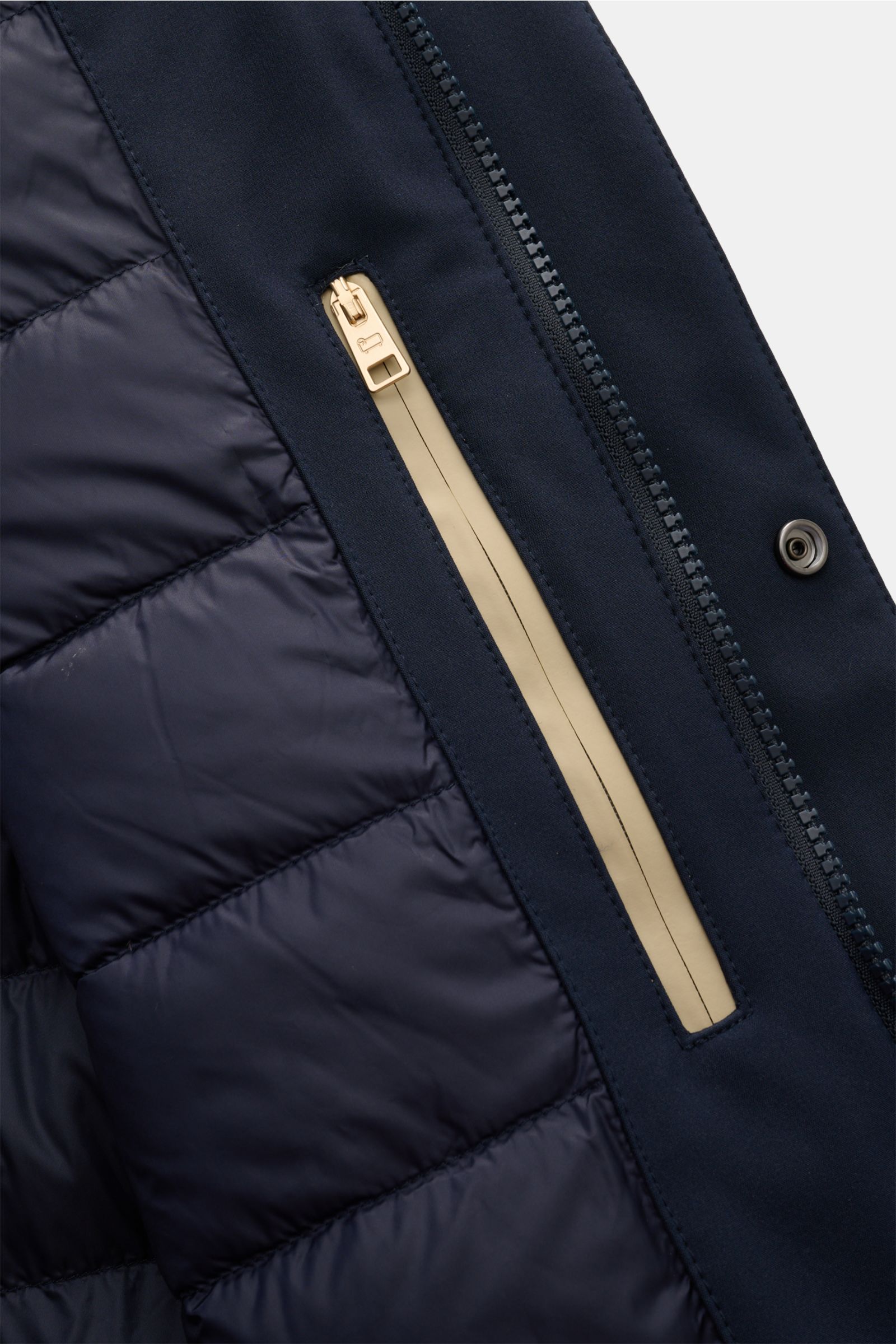 Close-up view of the Woolrich Softshell-Daunenparka schwarz showing the quilted, water-repellent down filling with smooth elastic microfiber and a beige zipper detail. Der moderne Softshell-Parka des Traditionslabels MOORER featurt markante Reißverschl