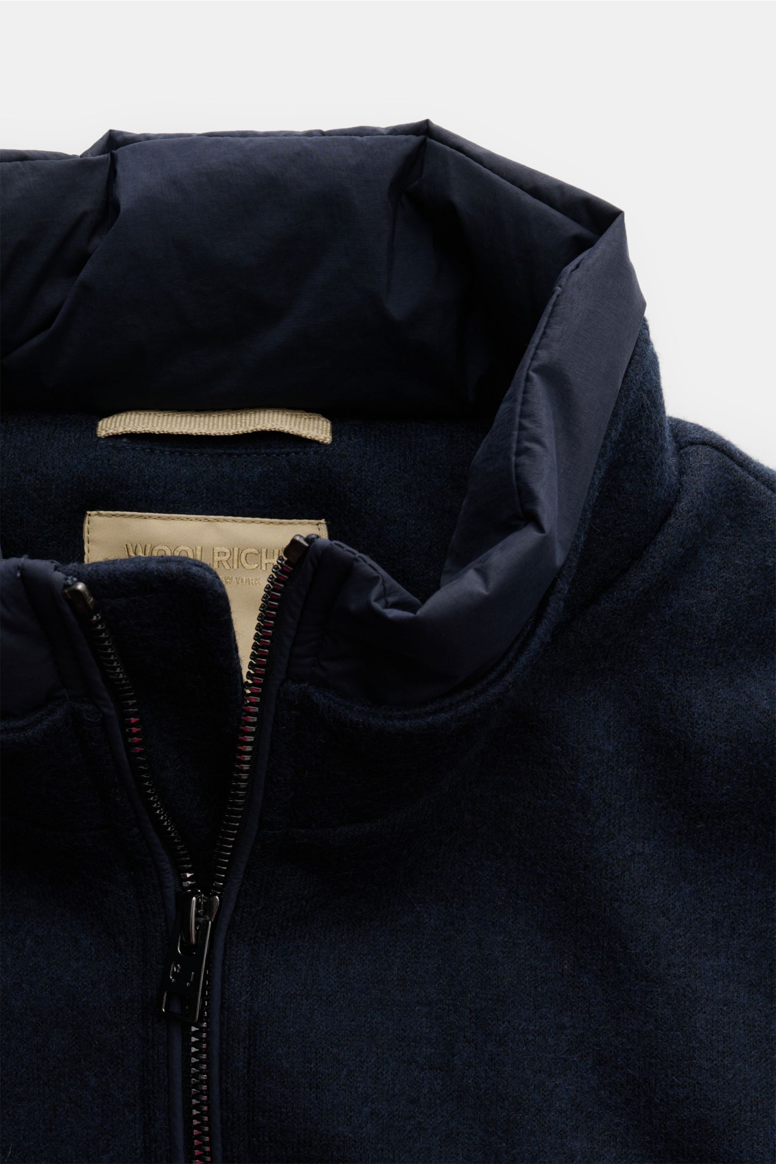 Nahaufnahme der Woolrich Daunenjacke navy von oben, aus Wolle und Microfaser, mit leichter Daunenfüllung, Slim Fit, Druckknopfleiste, variablem Kragen mit Knopfriegel, schrägen Leistentaschen, Ärmelabschlüssen mit Knopf, regulierbarer Taillenweite, gestep