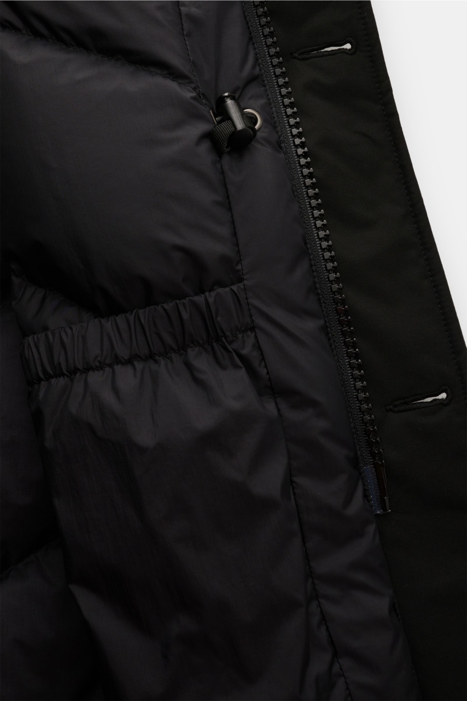 Close-up inside view of the Woolrich Daunenparka 'Arctic Parka' schwarz showing black quilted lining, elastic inner pocket, and zipper details. Kälte? Kann kommen. Der 'Arctic Parka' von WOOLRICH liefert sportiven Style und verlässliche Wärme bis –20 °C –