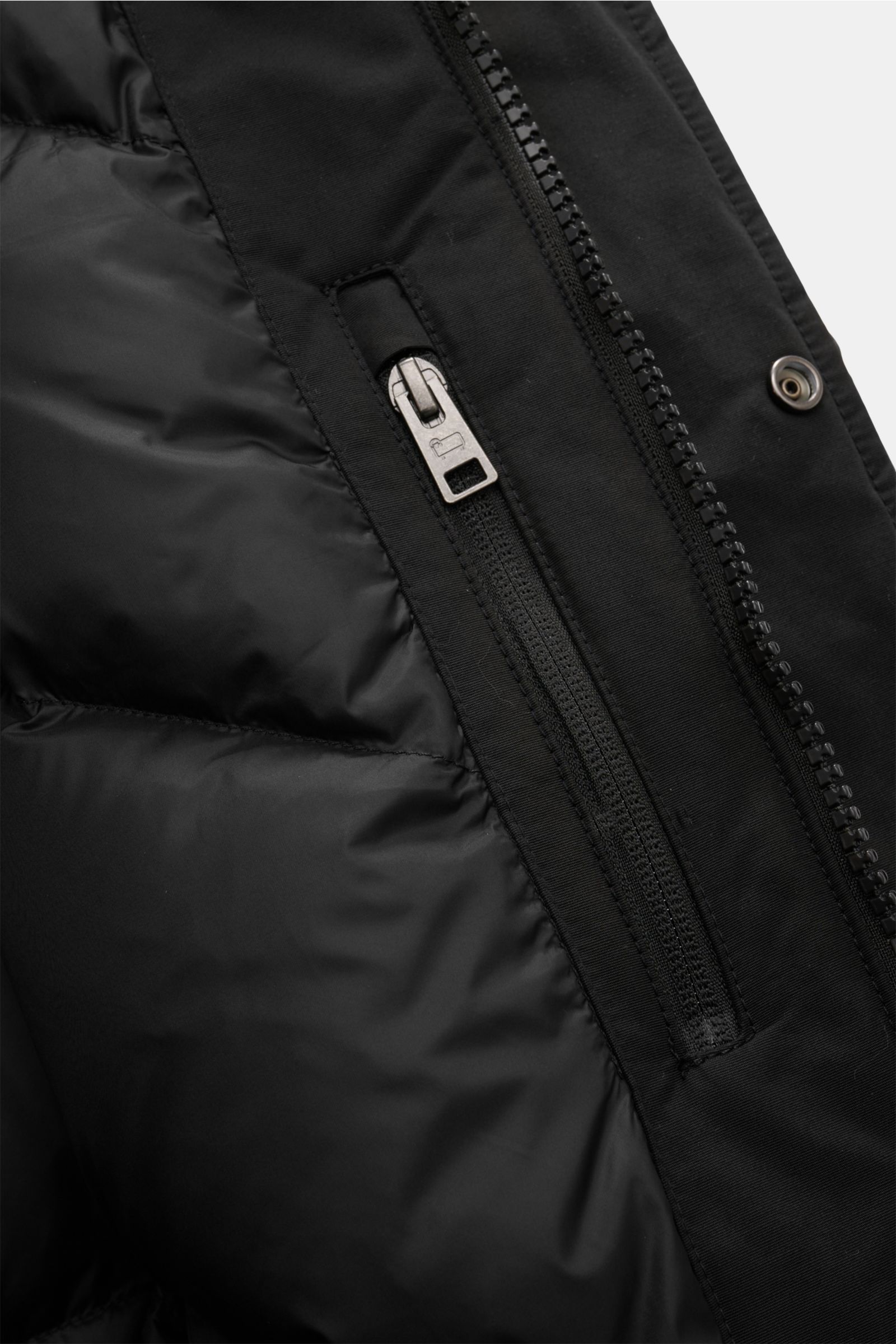 Innenansicht des schwarzen Woolrich Daunenparkas 'Polar High Collar' mit robustem Zwei-Wege-Reißverschluss und wind- und wasserabweisendem Ramar Cloth.