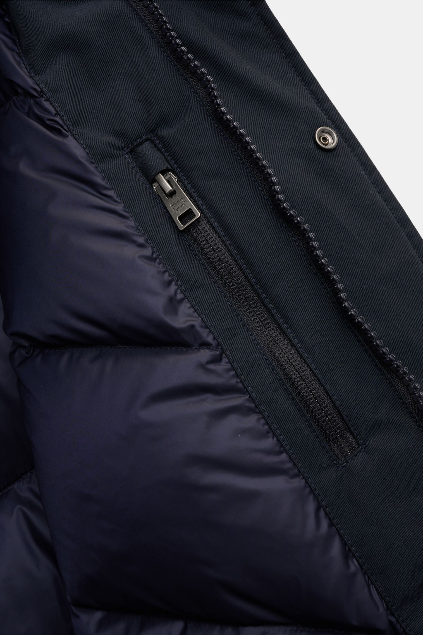 Nahaufnahme des robusten Zwei-Wege-Reißverschlusses vom Woolrich Daunenparka 'Polar High Collar' navy mit wind- und wasserabweisendem Material.