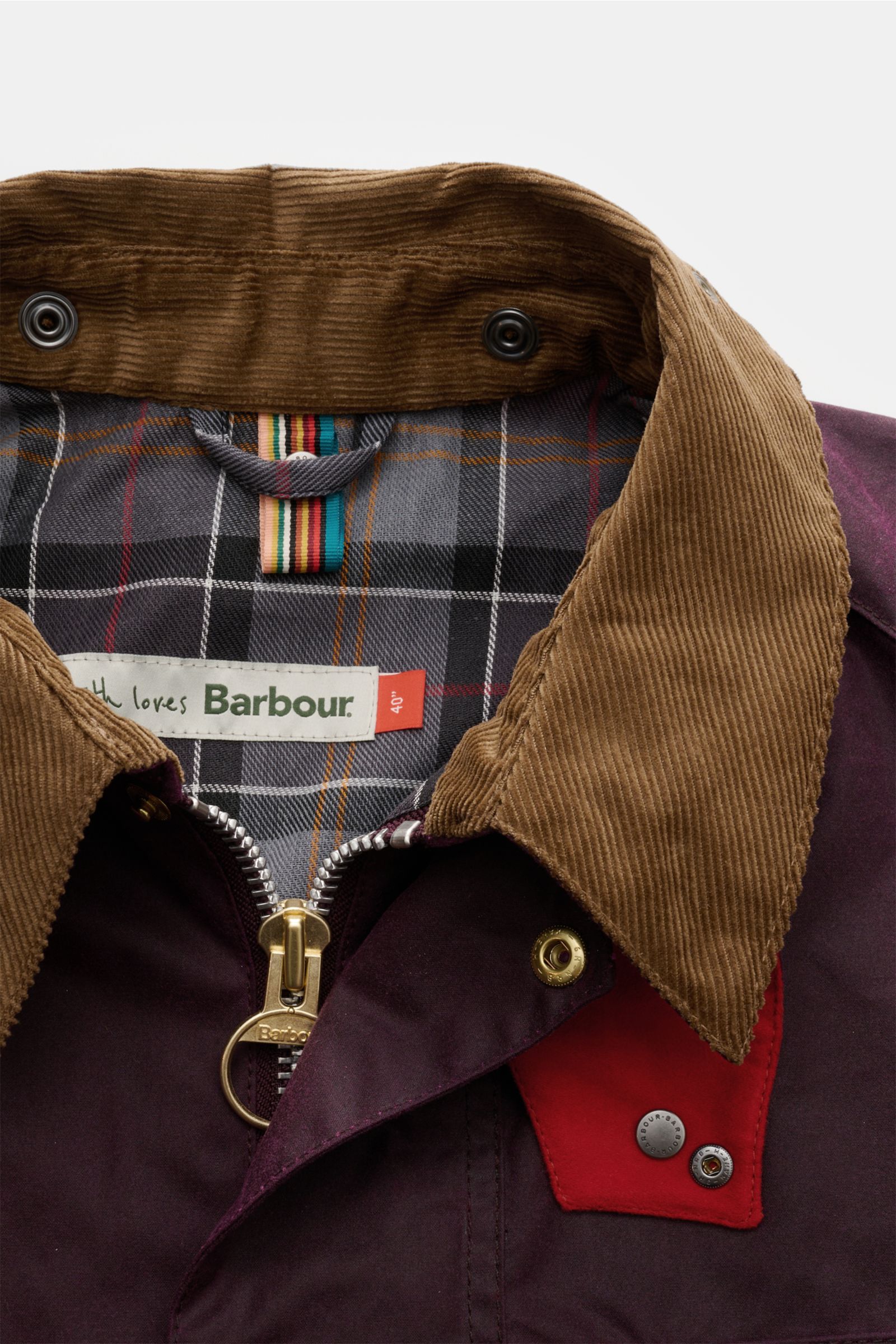 Nahaufnahme der Barbour Wachsjacke 'Transport' bordeaux von vorne, zeigt braunen Cordkragen, Tartan-Innenfutter mit Vogel-Prints, robusten Zwei-Wege-Reißverschluss und roten Kontrastriegel.