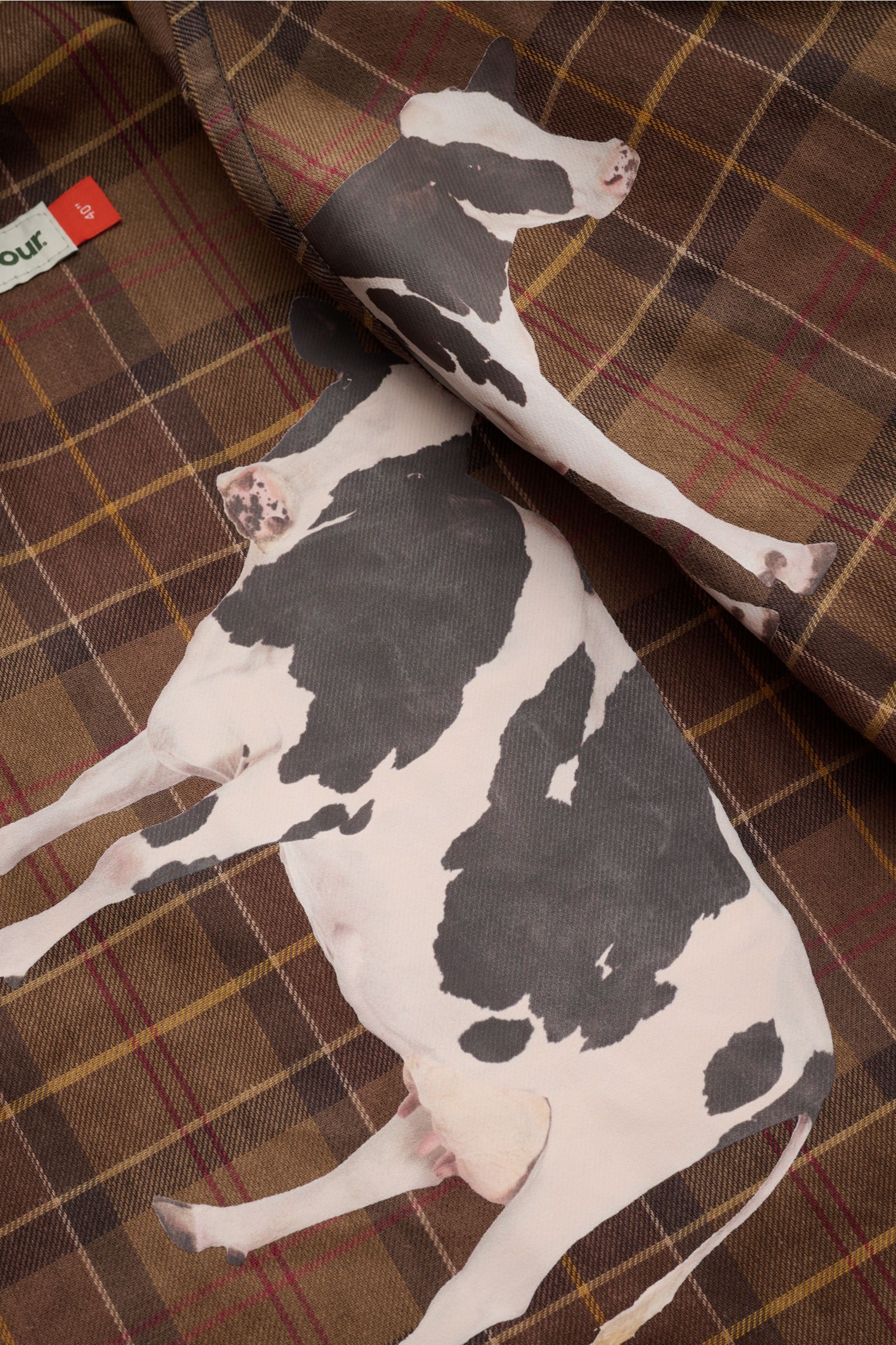 Nahaufnahme des typischen Tartan-Innenfutters mit Kuh-Print der Barbour Wachsjacke 'Bedale' navy aus gewachster Baumwolle.