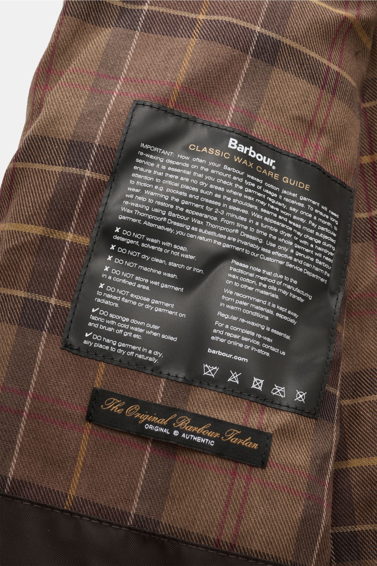 Close-up interior view of the Barbour Wachsjacke 'Bedale' navy/bordeaux/petrol showing the classic wax care guide label on the brown tartan lining.

Gut gerüstet für die Übergangszeit: Diese Variante der 'Bedale' Jacke gehört zur Kooperationskollektion