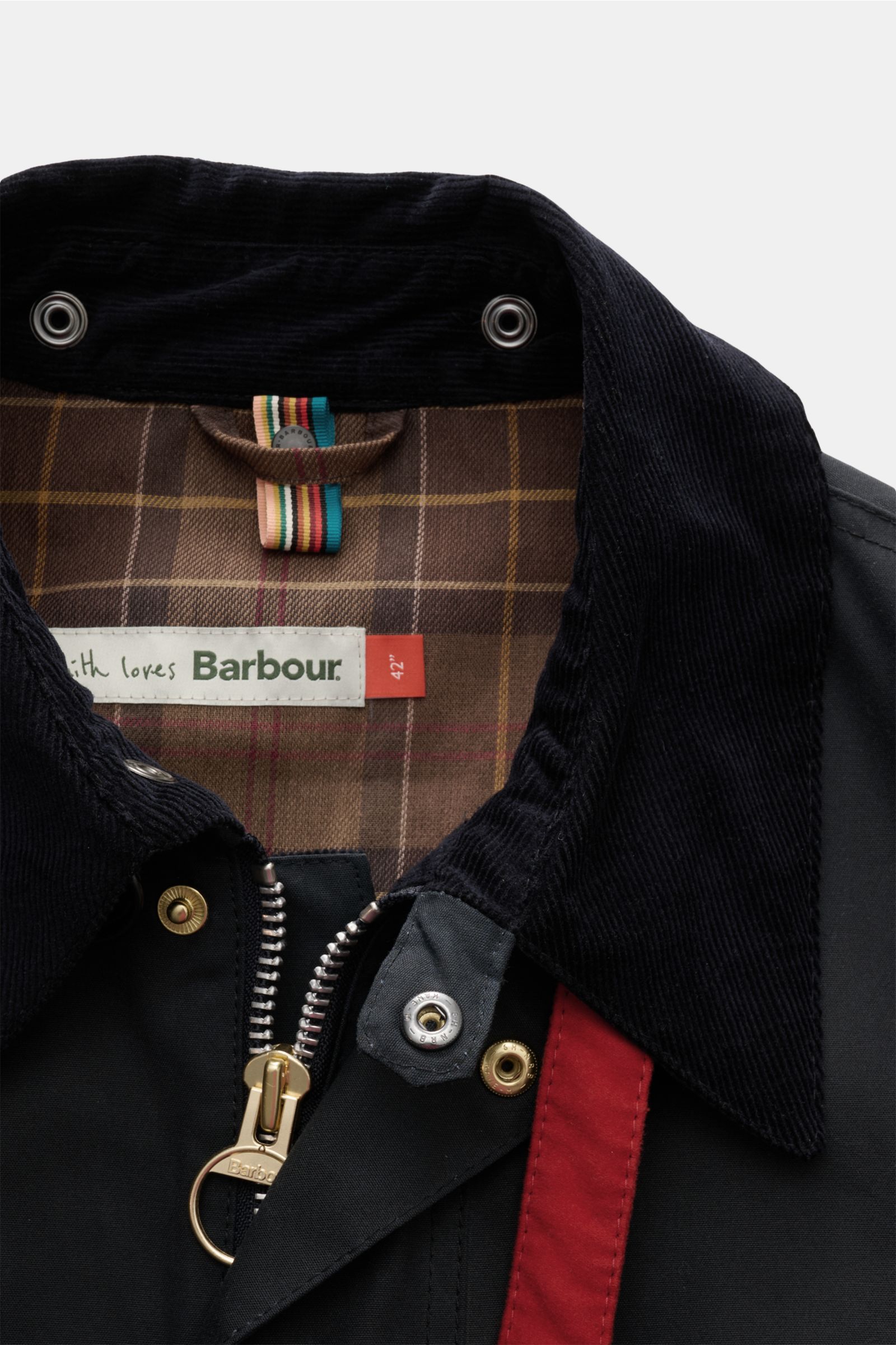 Close-up front view of the Barbour Wachsparka 'Beeston' navy showing the navy corduroy collar, gold zipper, red contrasting strip, and brown tartan lining. Gut gerüstet für die Übergangszeit: Der 'Beeston' Wachsparka gehört zur Kooperationskollektion von 