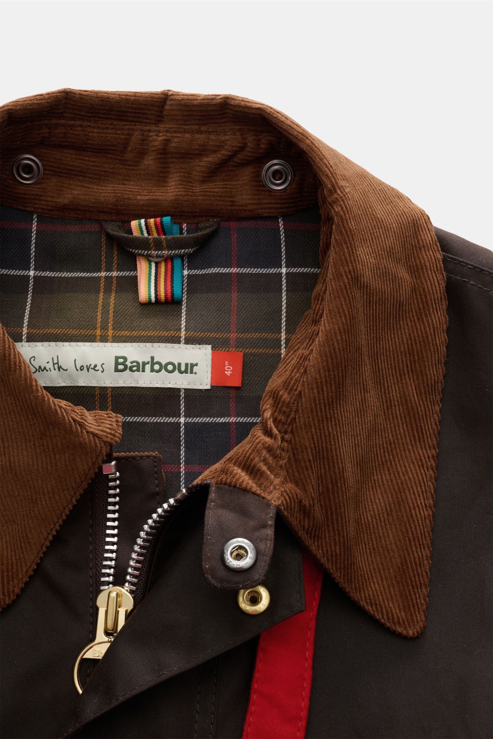 Nahaufnahme des Kragens aus Cord des Barbour Wachsparkas 'Beeston' dunkelbraun mit Tartan-Futter, robuster Reißverschluss und Druckknöpfen.