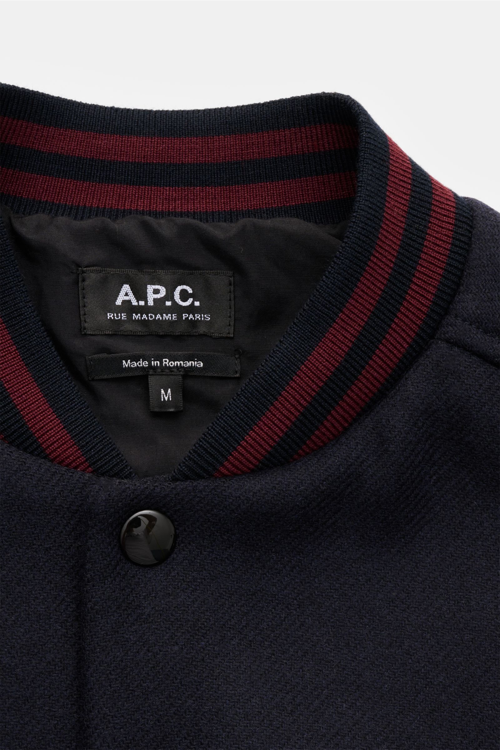 A.P.C. Blouson 'Micky' dark navy in Nahaufnahme von oben, Woll-Mix, College-Style, Blousonkragen mit roten Streifen, Druckknopf.