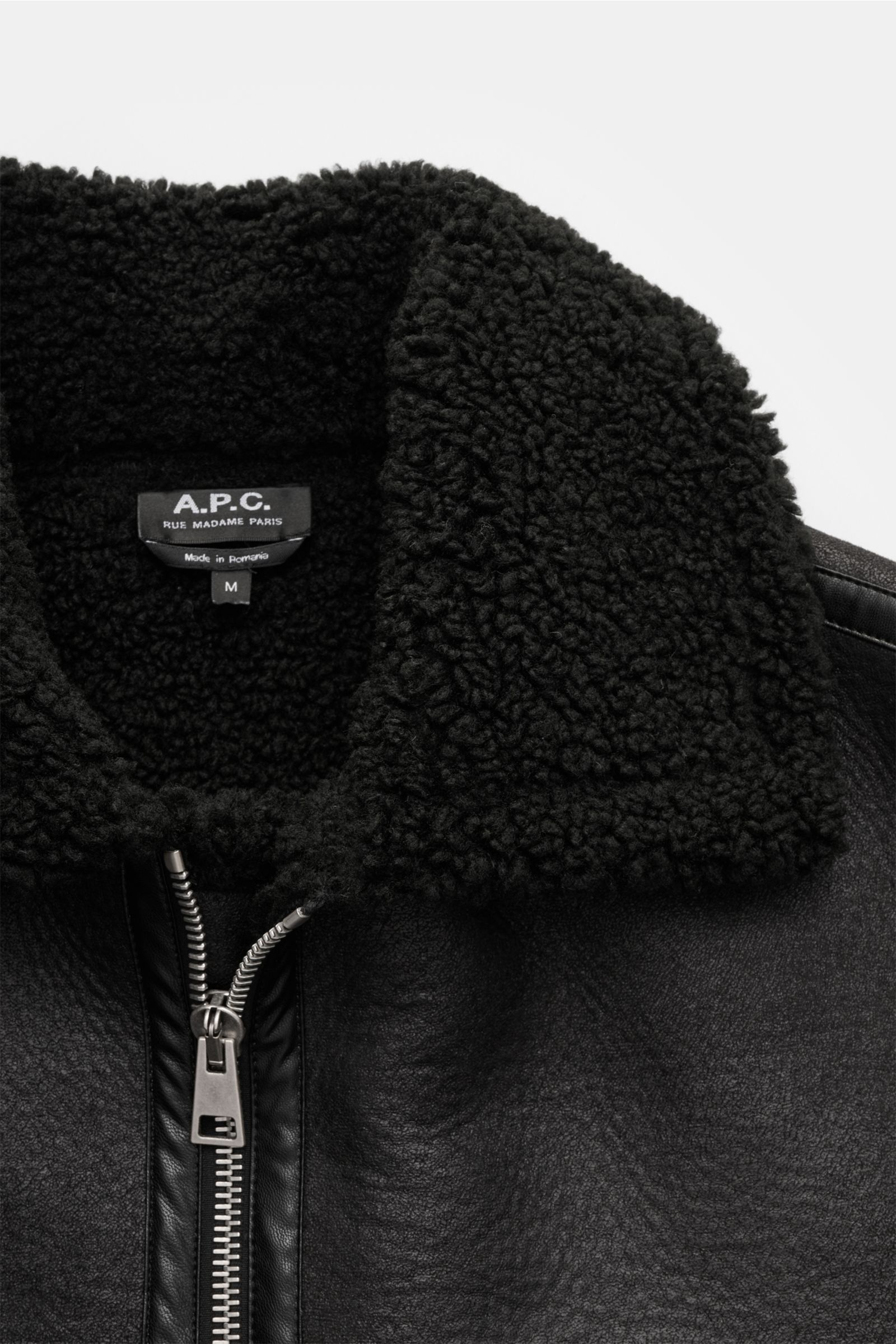 A.P.C. Jacke 'Tommy' schwarz, Nahaufnahme von oben, luxuriöse Lammfelloptik, breiter Umlegekragen, Metall-Reißverschluss, Slim Fit, weiche Microfaser.