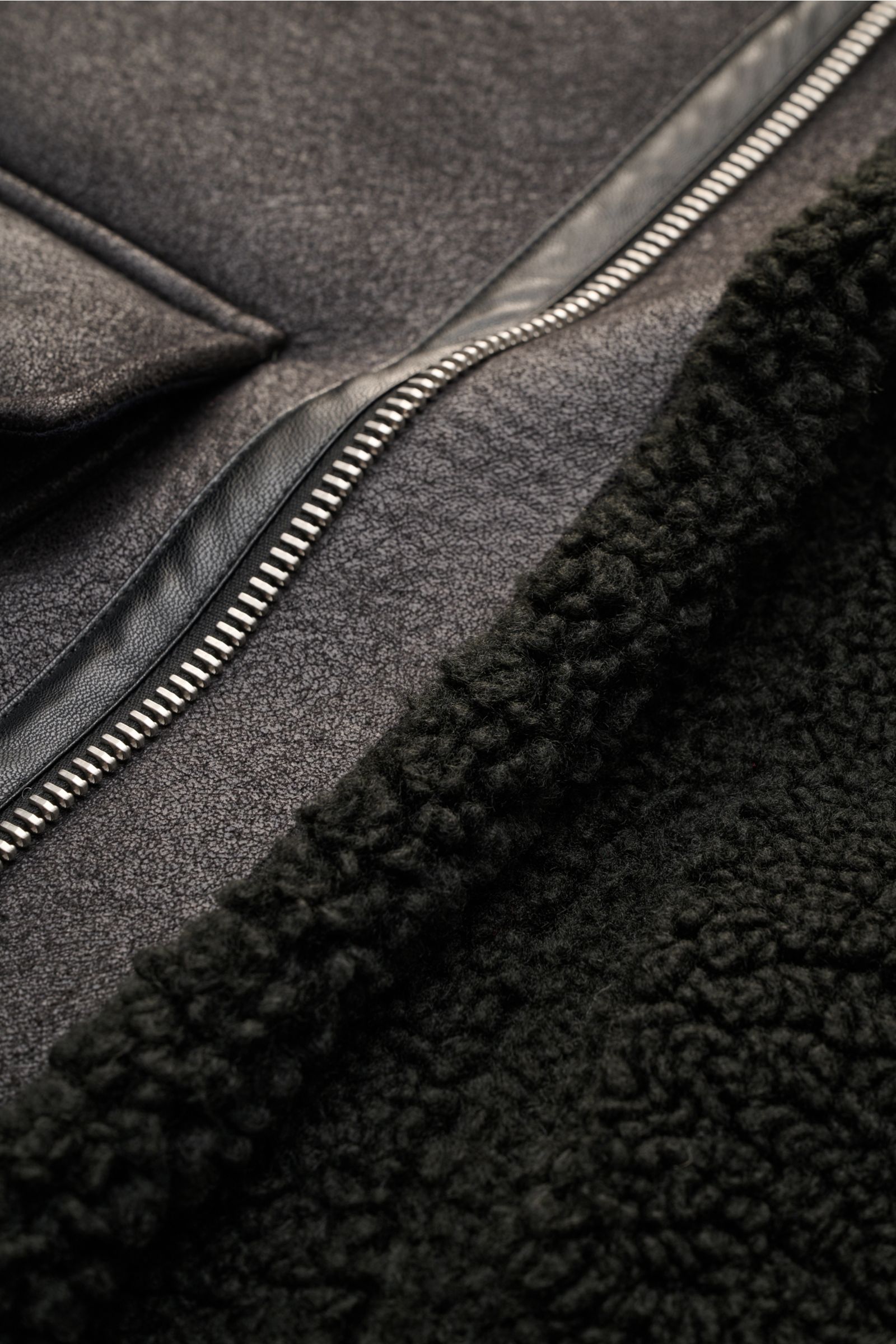 Nahaufnahme der A.P.C. Jacke 'Tommy' schwarz mit luxuriöser Lammfelloptik, Metall-Reißverschluss und breitem Umlegekragen.