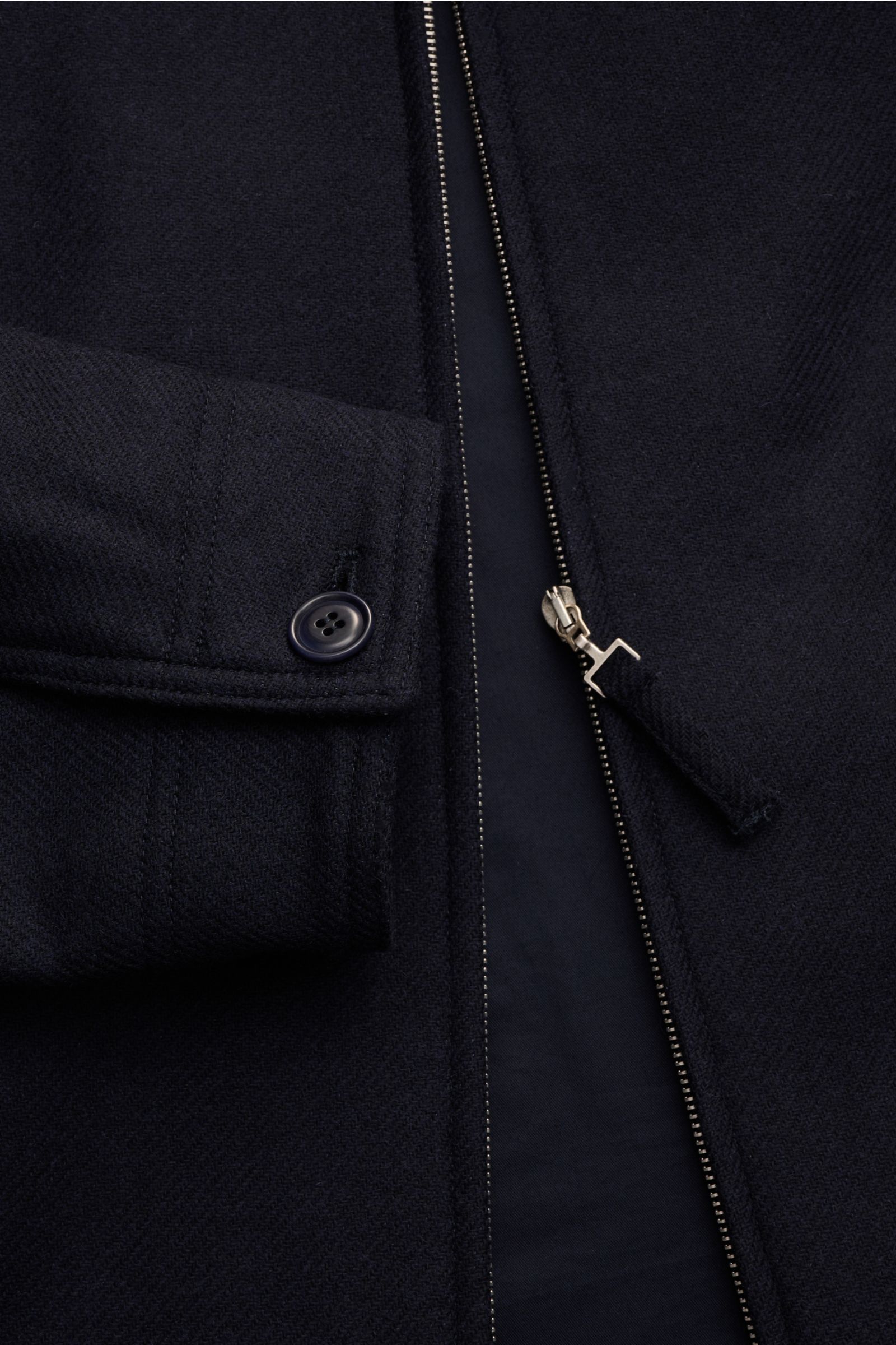 Close-up front view of the A.P.C. Jacke 'Chase' navy, made from a wool-microfiber mix with a slightly textured feel, featuring a zipper, buttoned cuff, and viscose lining. Die Jacke 'Chase' vom Französischen Label A.P.C. fertigt ihr sportives Modell aus W