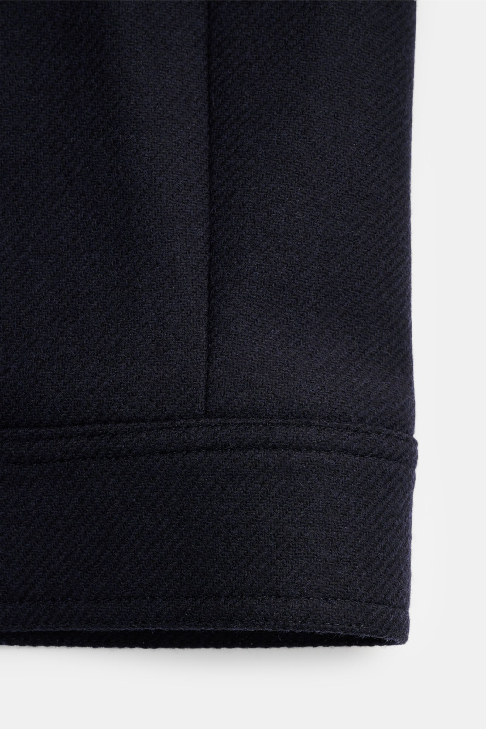 Close-up view of the navy sleeve of the A.P.C. Jacke 'Chase' showing the wool-microfiber mix fabric with a lightly textured, grippy feel and precise stitching. The jacket features a regular fit, zipper, turn-down collar, raglan sleeves, slanted welt pocke