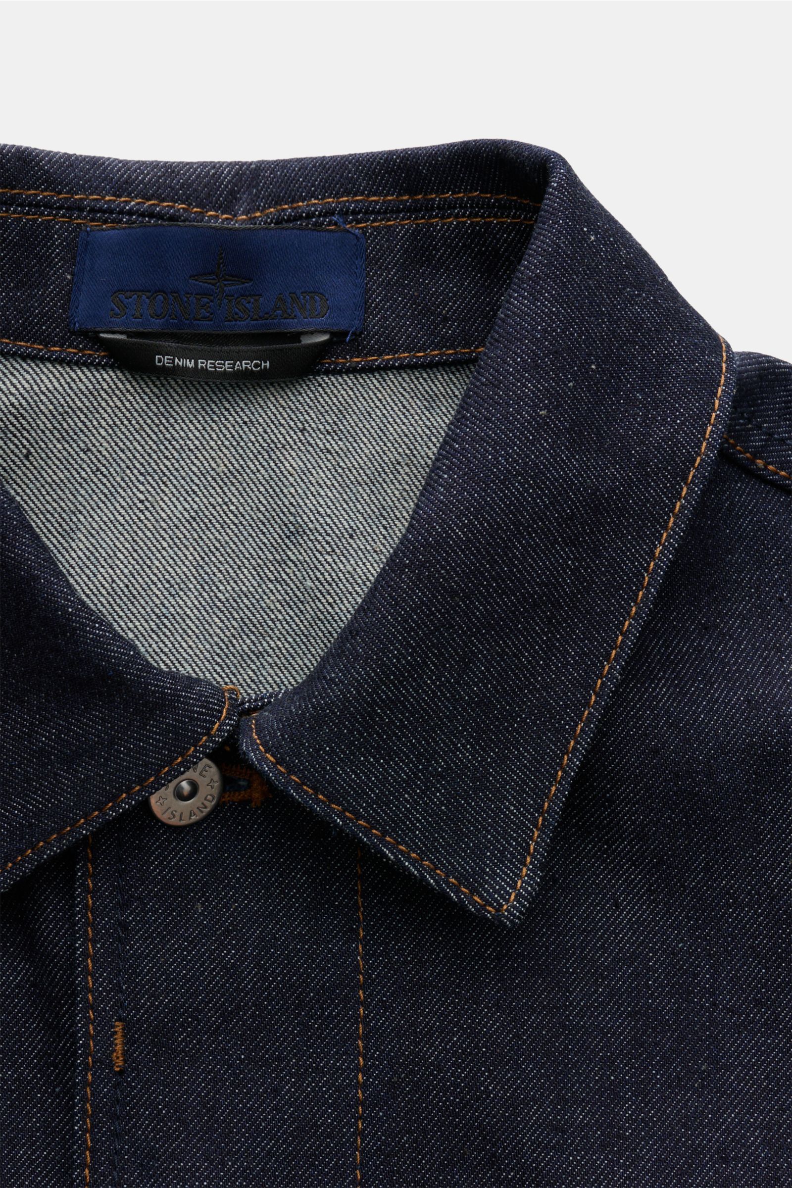 Stone Island Jeansjacke 'Indigo Denim-Raw' navy im Close-up von oben mit Umlegekragen, verdeckter Knopfleiste und Denim-Baumwolle.
