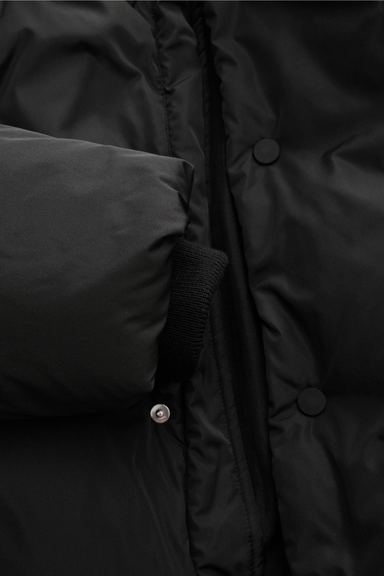 Nahaufnahme der Ami Paris Daunenjacke schwarz von innen mit wattiertem Kragen, Rippbündchen, Microfaser und Knopfleiste.