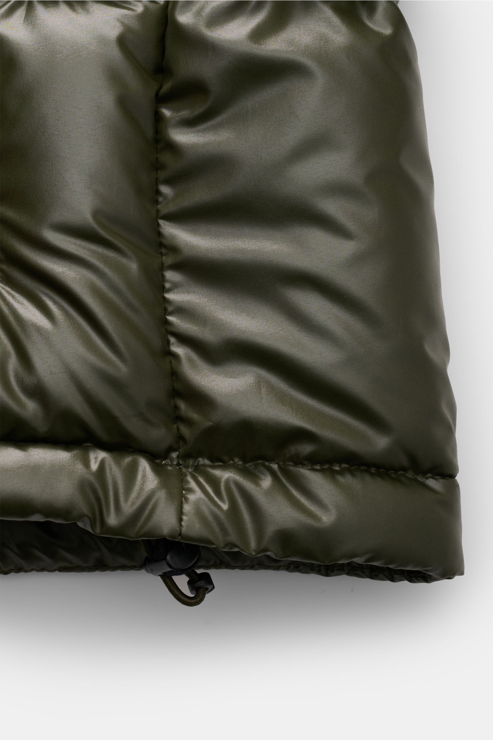 Close-up of the hem of the Polo Ralph Lauren Daunenjacke oliv puffer jacket, showing its shiny olive fabric and adjustable drawstring.

Setzen Sie ein Statement - auch im Winter: Diese Daunenjacke von POLO RALPH LAUREN wärmt dank ihrer Daunenfüllung ga