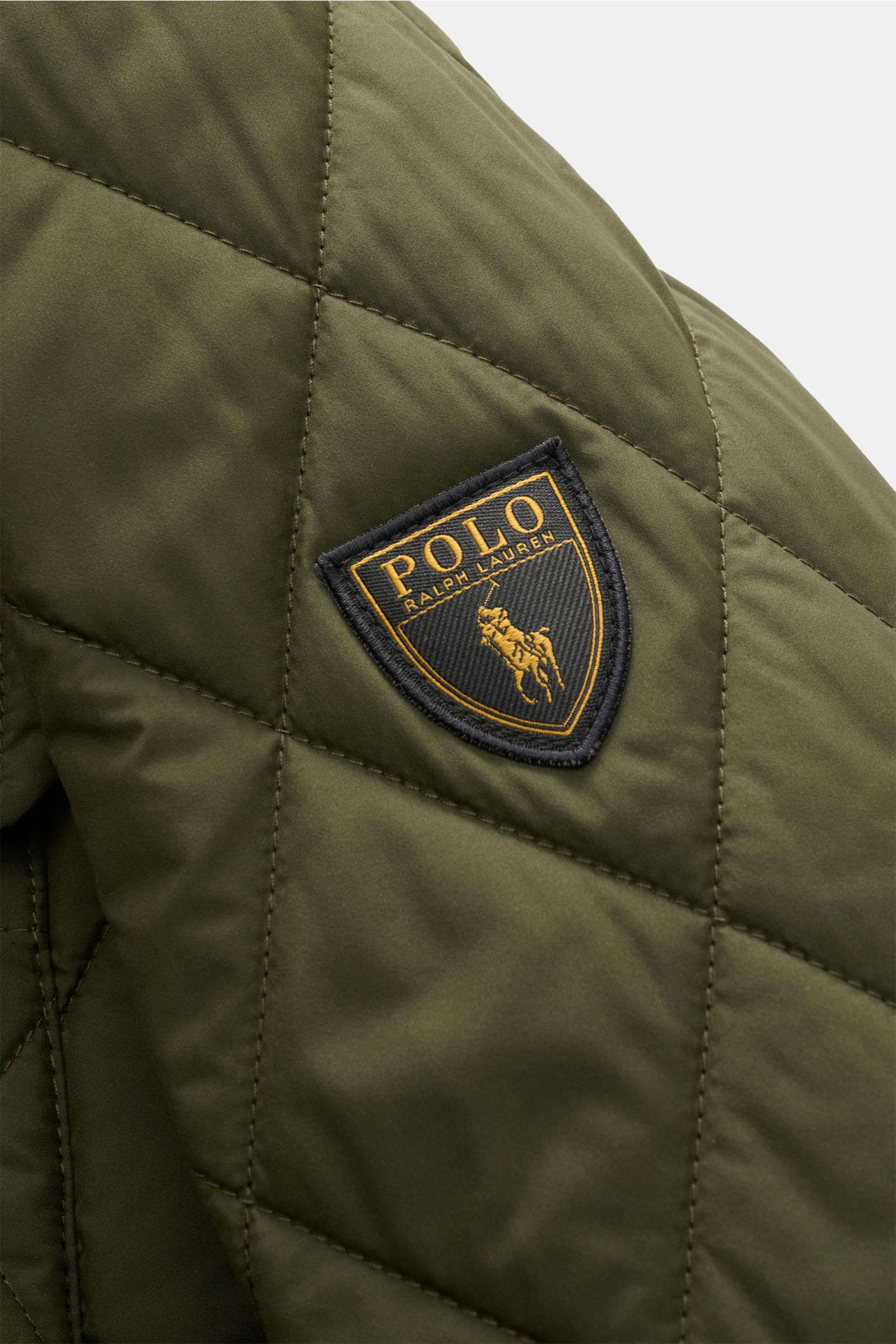 Alt-Tag (124 Zeichen):
Nahaufnahme der olivgrünen Polo Ralph Lauren Steppjacke 'Beaton' mit klassischem Steppmuster und markantem Logo-Patch am Ärmel.