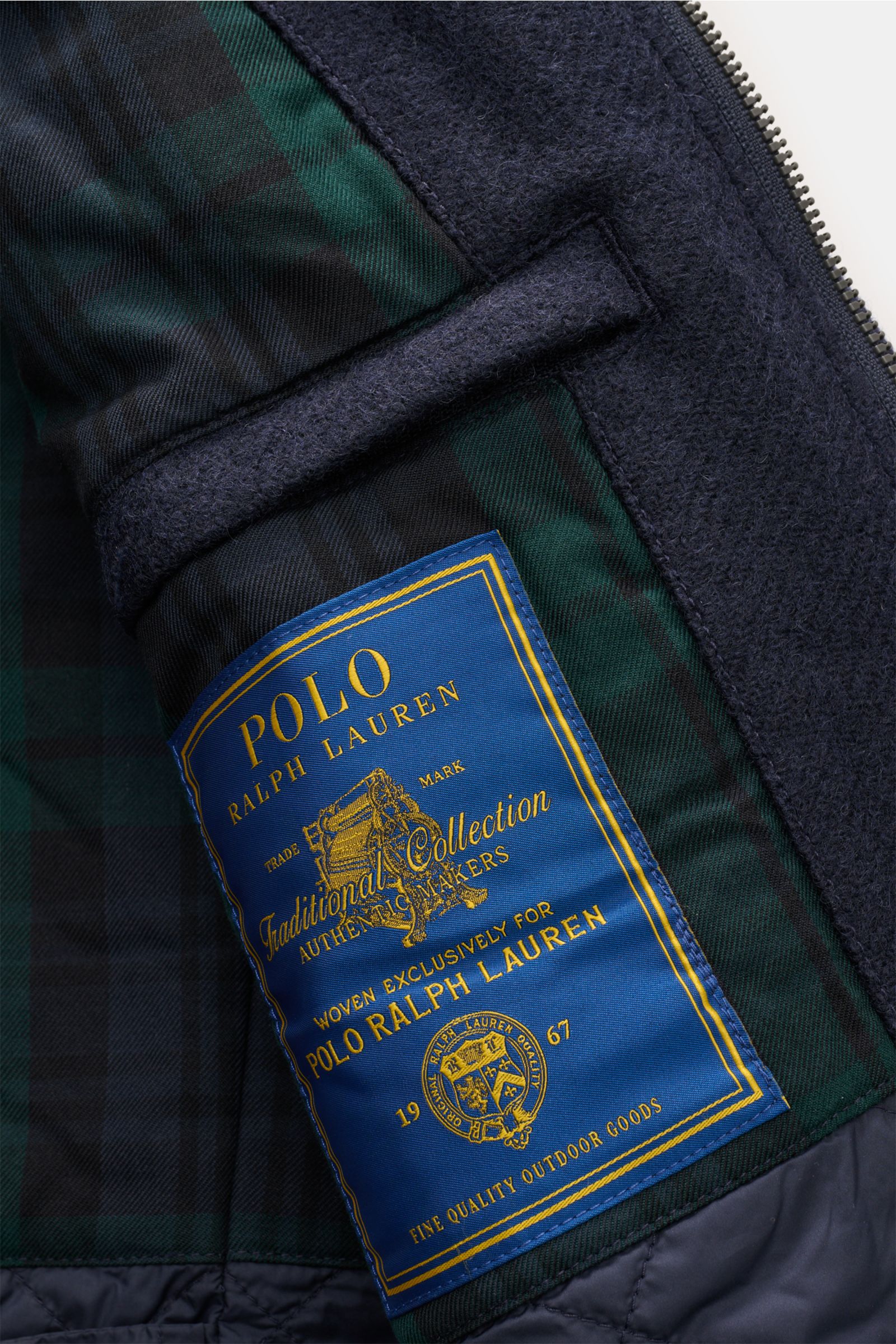 Nahaufnahme der Innenseite der Polo Ralph Lauren Jacke 'Langdon' navy, italienischer Wolltwill, isolierende Microfaser-Fütterung, Innentasche mit blauem Label, grün-schwarz kariertes Futter.
