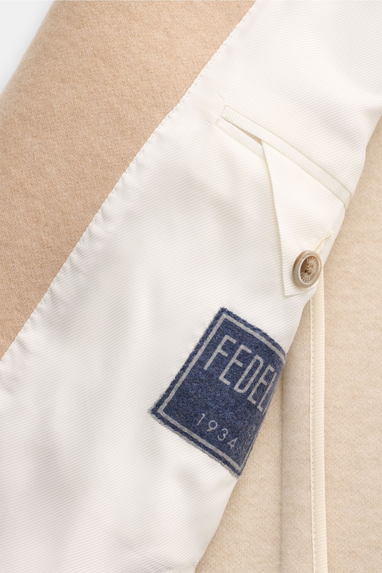 Nahaufnahme der halb gefütterten Innenansicht einer Fedeli Cashmere Jacke beige mit reiner Cashmere-Qualität, weichem Griff, Slim Fit, Stehkragen, Vier-Knopf-Leiste, klassischer Brusttasche, aufgesetzten Hüfttaschen, Kissing Buttons, rückwärtigen Seitensc