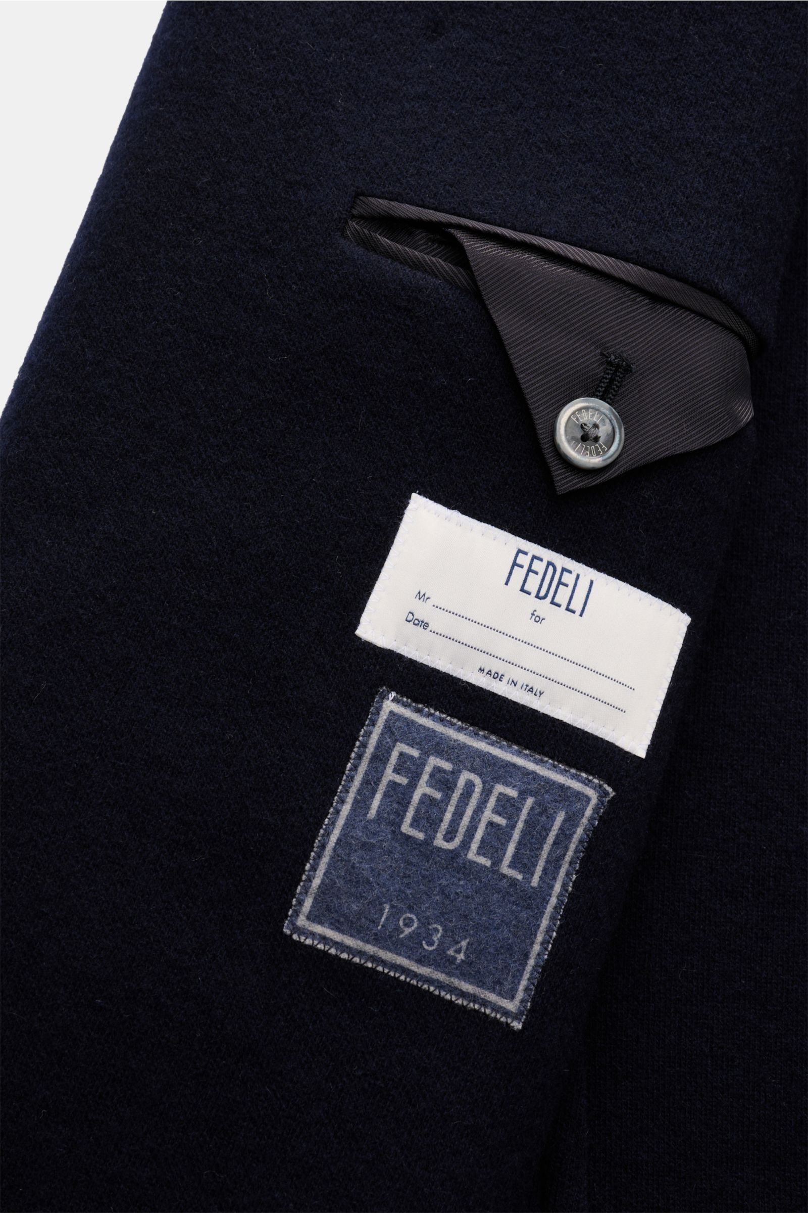 Nahaufnahme der Innenseite der Fedeli Cashmere Cabanjacke navy mit Label, reiner Cashmere, weicher Griff, Slim Fit, variablem Kragen, Vier-Knopf-Leiste, schrägen Leistentaschen, halb gefüttert und zwei Innentaschen.