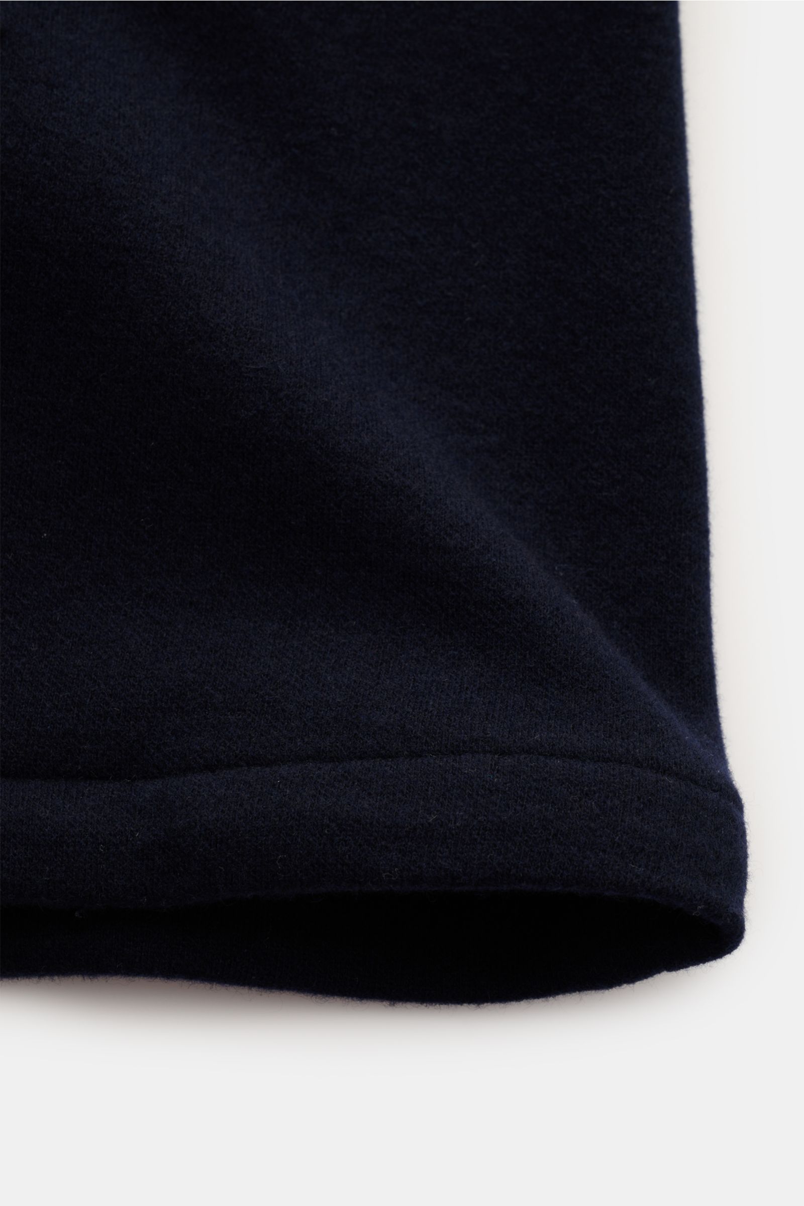 Das Bild zeigt eine Nahaufnahme des unteren Saums der Fedeli Cashmere Cabanjacke navy aus reiner Cashmere, weicher, geschmeidiger Griff, Slim Fit, variabler Kragen, Vier-Knopf-Leiste, schräge Leistentaschen, halb gefüttert, zwei Innentaschen, fotografiert