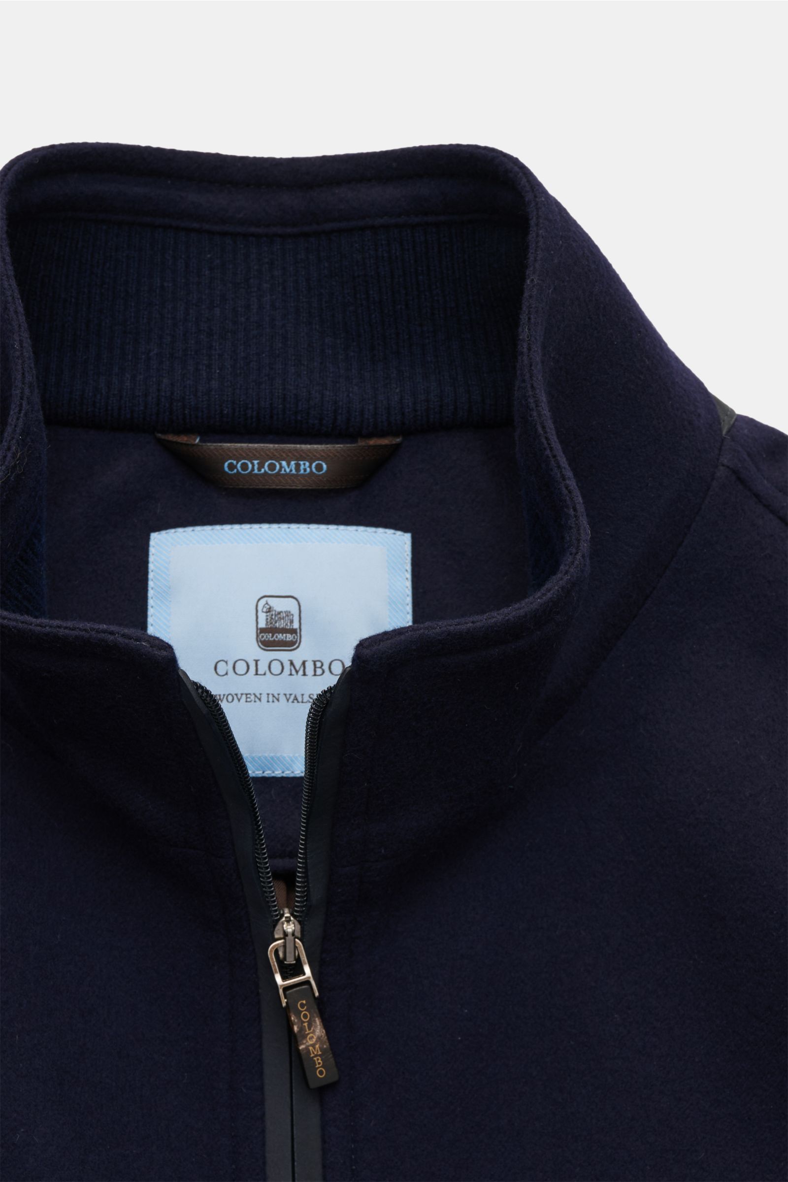 Nahaufnahme der Colombo Jacke navy von vorne mit offenem Zwei-Wege-Reißverschluss, Stehkragen mit Rippstrick, reine Wolle, Slim Fit, Leder-Details.