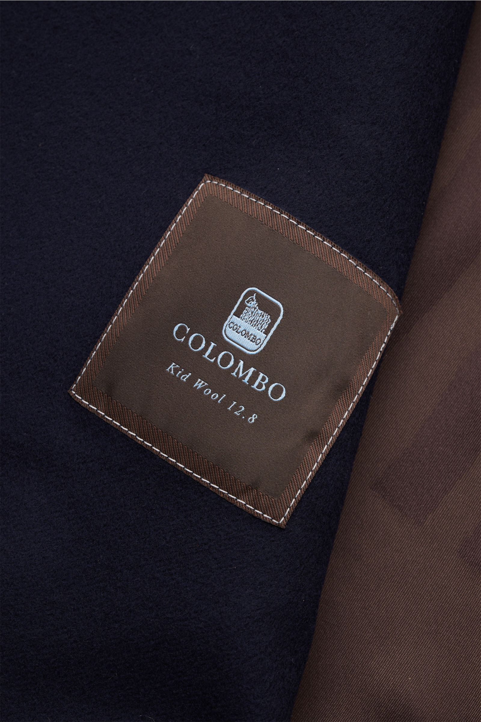 Alt-Tag (124 Zeichen): Nahaufnahme des Innenfutters der Colombo Jacke navy mit braunem Label, weicher reiner Wolle, Slim Fit und Lederdetails.
