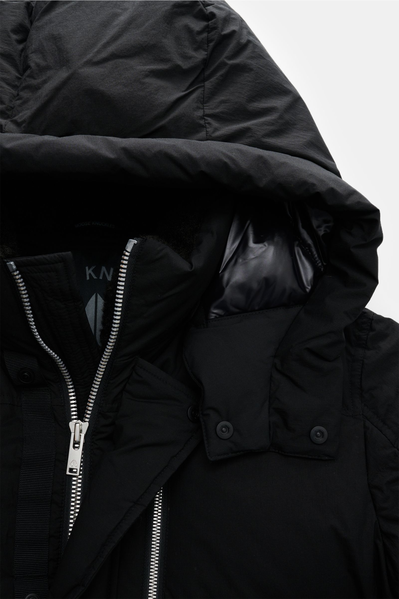 Close-up front view of the black Moose Knuckles Daunenjacke 'Everest 3Q' showing zipper, buttoned wind flap, and hood with fur trim. Höchster Komfort bei jeder Temperatur: Die Daunenjacke von MOOSE KNUCKLES vereint exzellente Wärmeisolierung mit außergewö