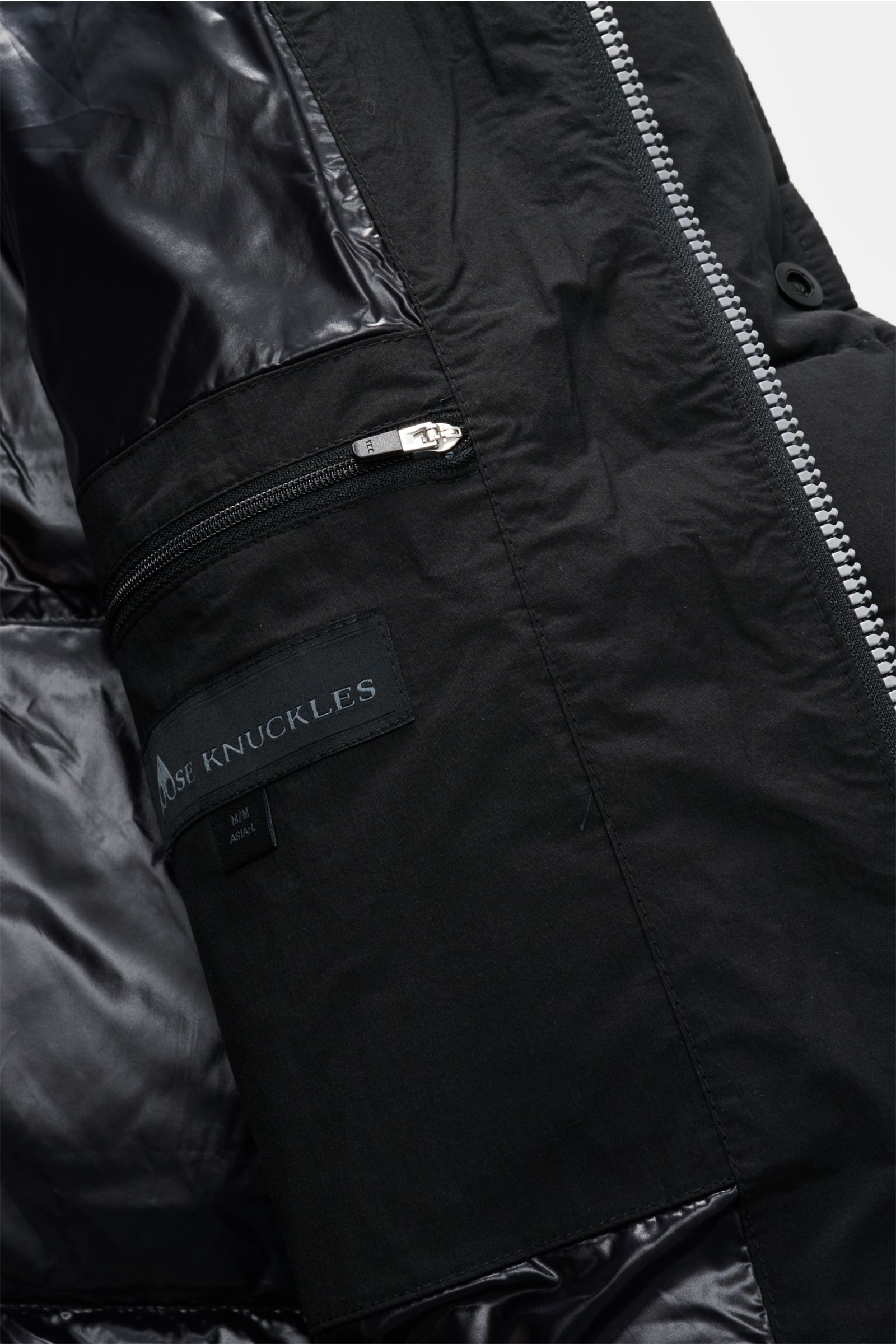 Close-up interior view of Moose Knuckles Daunenjacke 'Everest 3Q' schwarz showing zippered inner pocket, black cotton-microfiber blend, and shiny lining.

Höchster Komfort bei jeder Temperatur: Die Daunenjacke von MOOSE KNUCKLES vereint exzellente Wärm