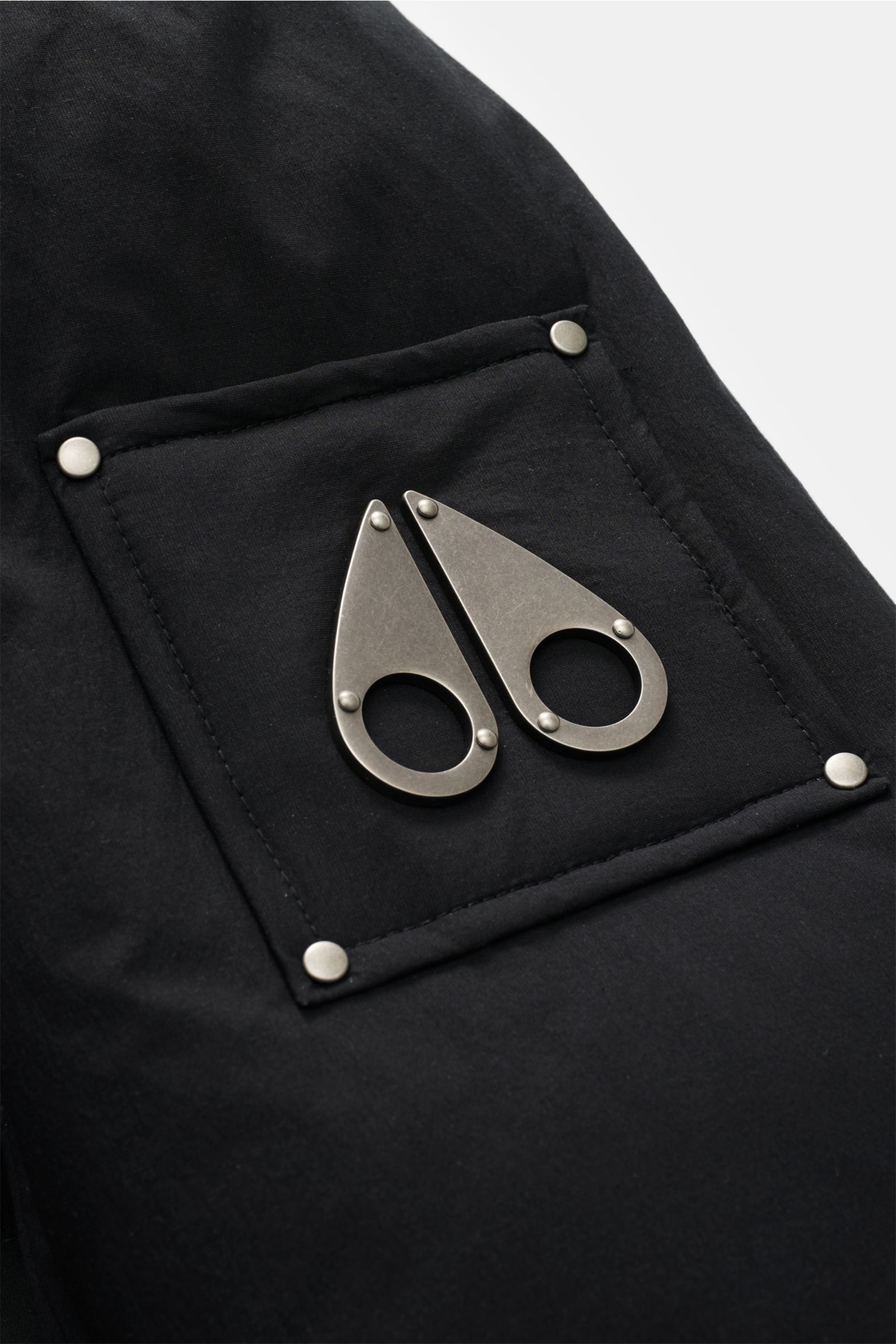 Close-up view of the sleeve with metal logo on the black Moose Knuckles Daunenjacke 'Everest 3Q' schwarz, showcasing material and detailing.

Höchster Komfort bei jeder Temperatur: Die Daunenjacke von MOOSE KNUCKLES vereint exzellente Wärmeisolierung m