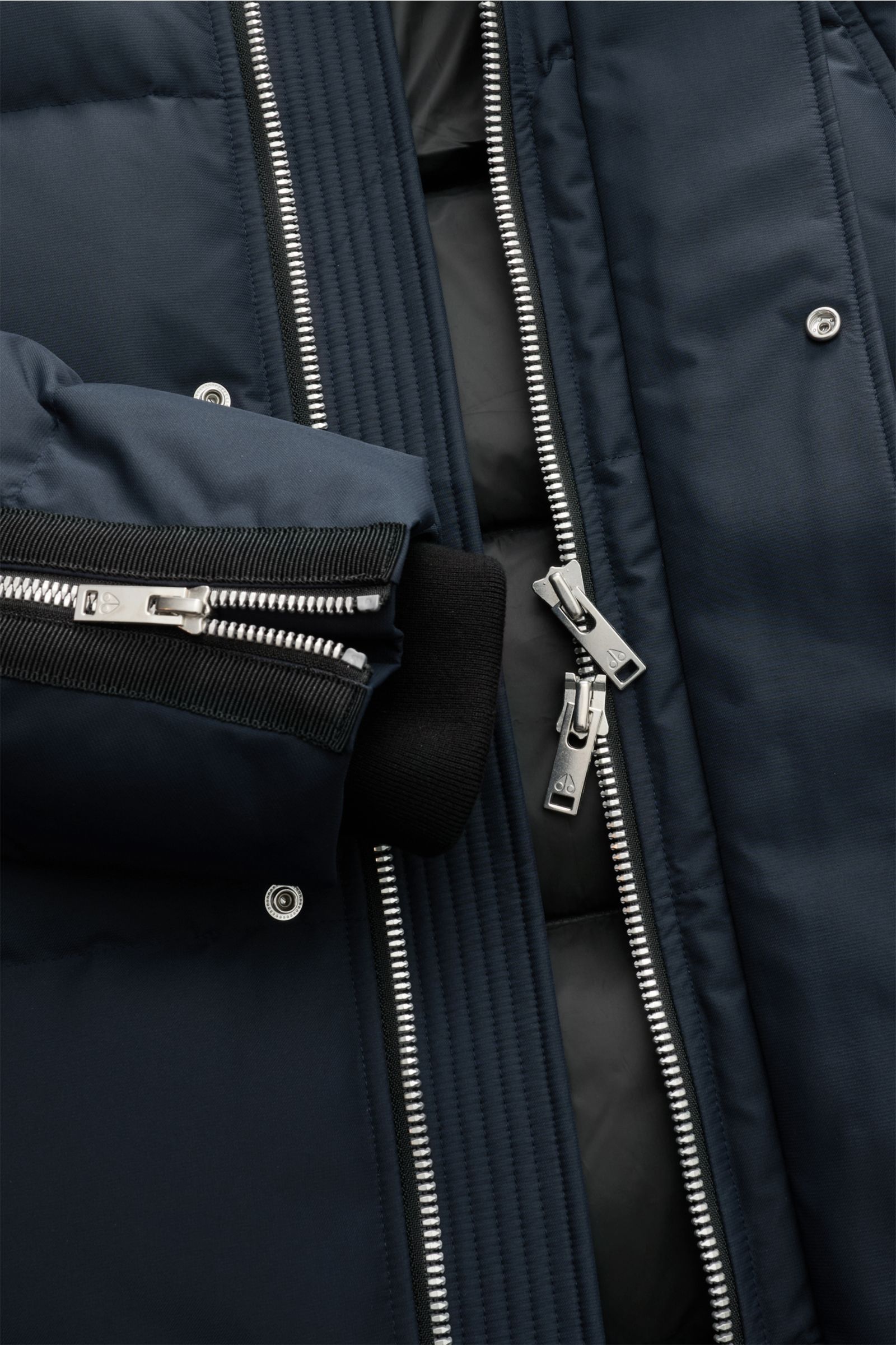 Close-up front view of Moose Knuckles Down parka 'Cloud parka Neoshear' navy, showing silver two-way zipper, snap buttons, and cuff zipper. With the 'Cloud' series, MOOSE KNUCKLES presents reinterpretations of its classics that look just as stylish but ar