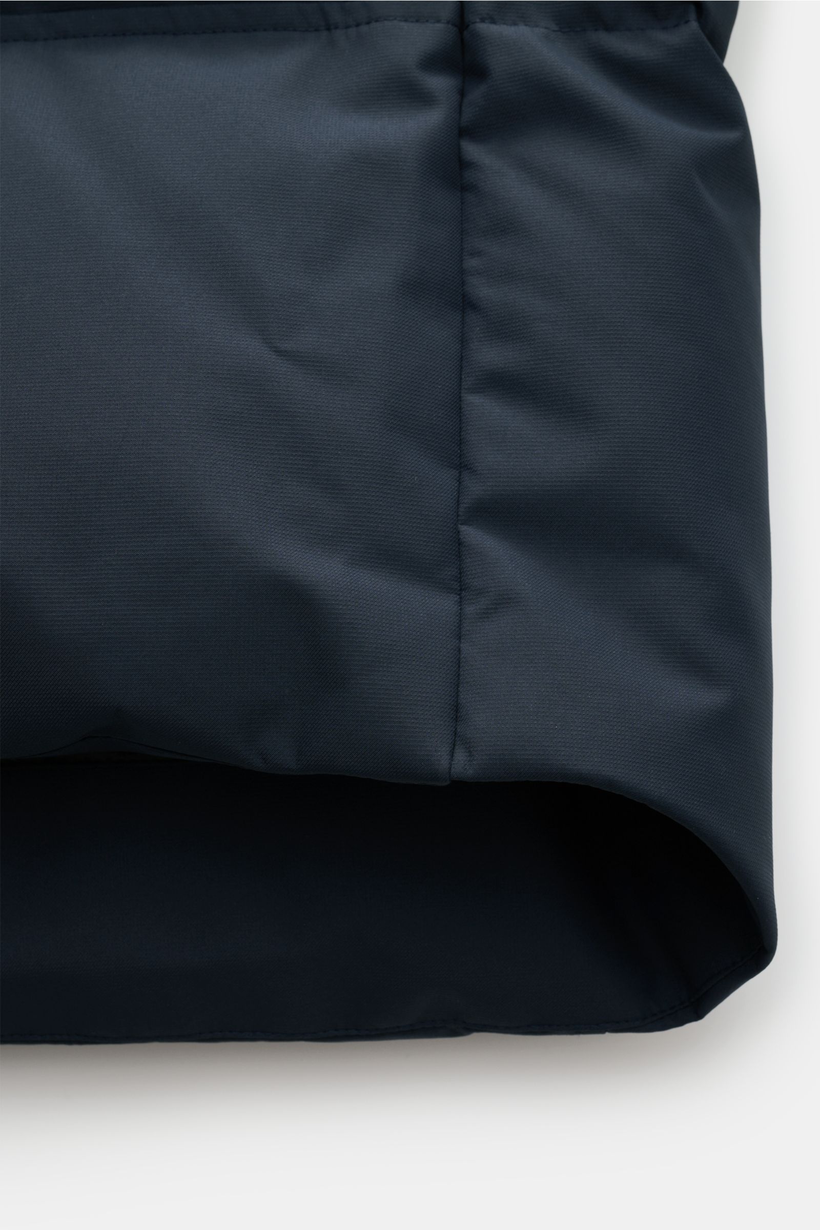 Close-up side view of navy Moose Knuckles Down parka 'Cloud parka Neoshear' showing smooth, water-repellent microfiber fabric and curved hem.