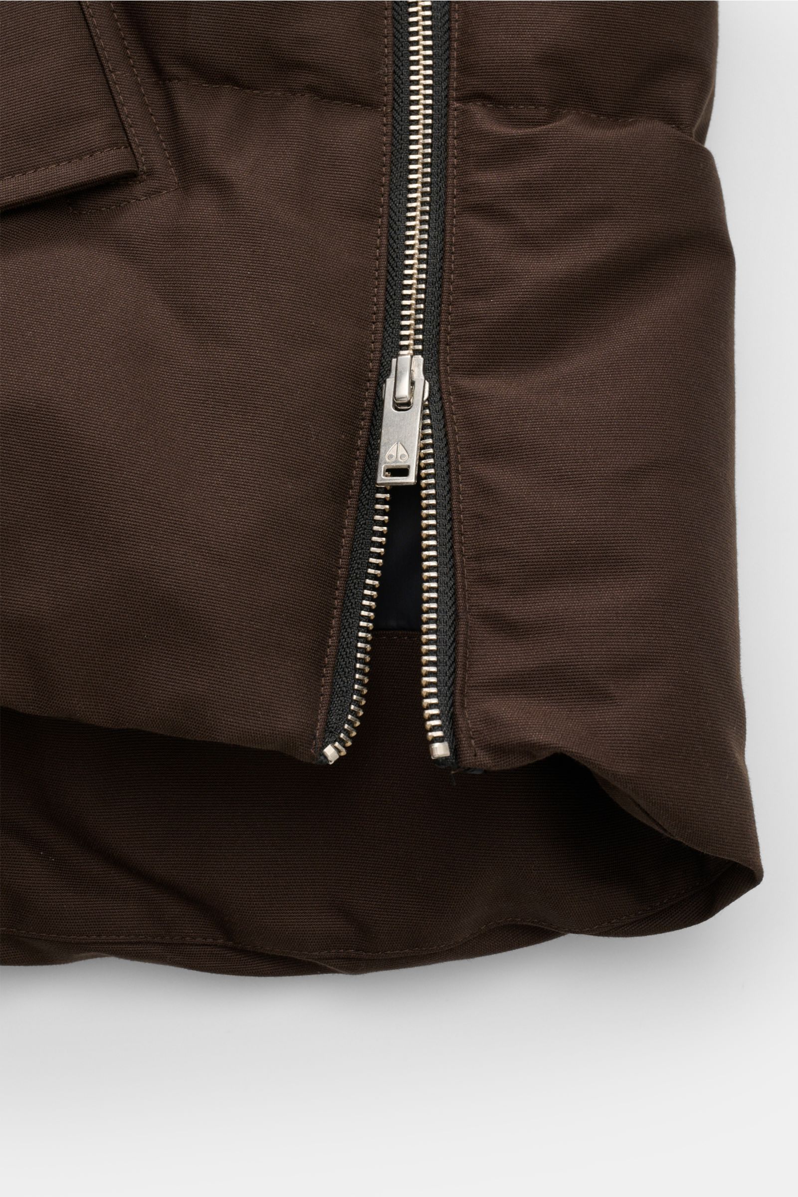 Close-up front-bottom view of the Moose Knuckles Down jacket 'Original 3q Neoshear' dark brown showing the silver zipper partially open on durable cotton and microfiber fabric. Effortlessly protects against even extreme cold: With its high-quality 90/1