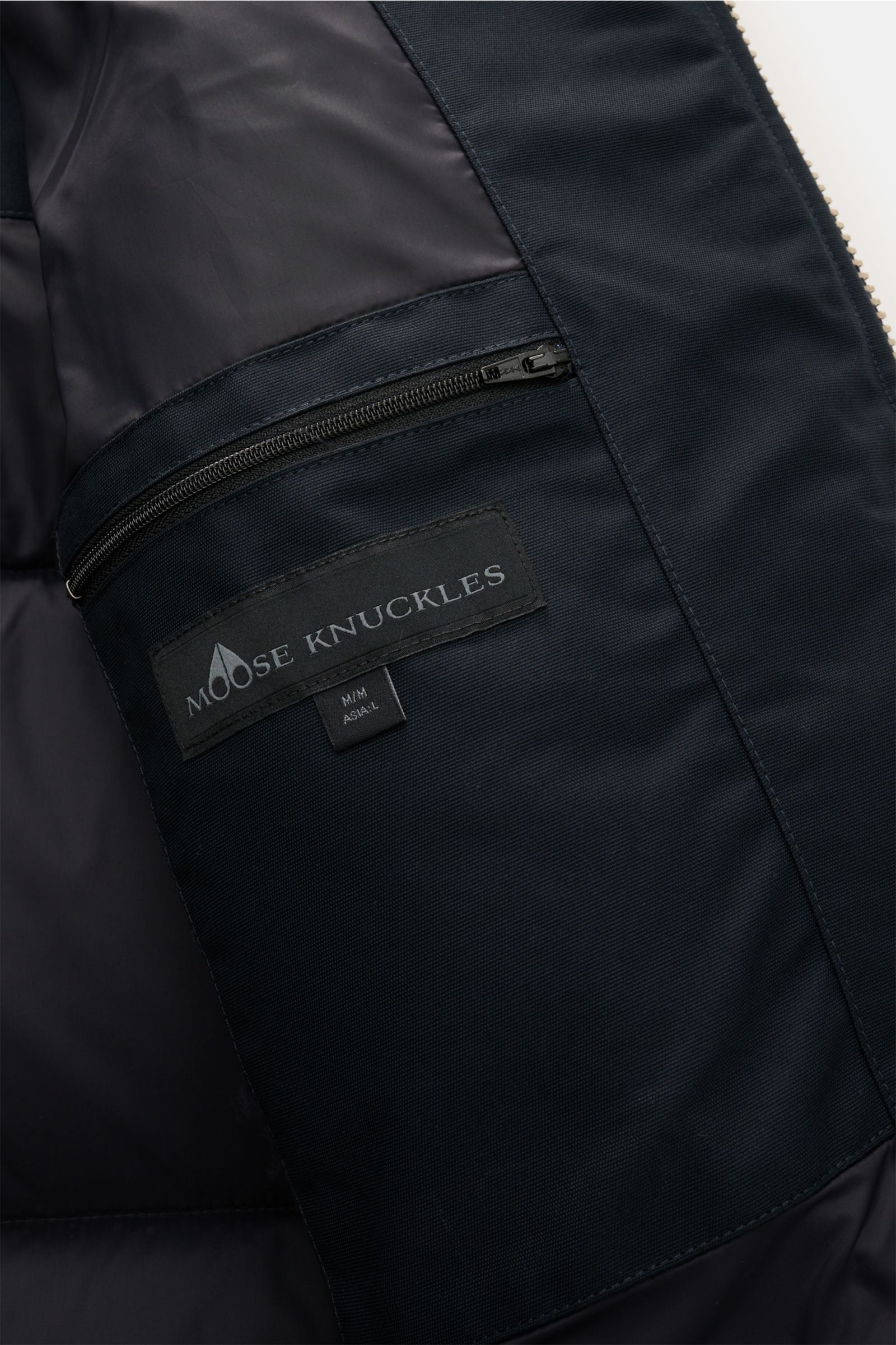 Close-up interior view of the Moose Knuckles Down jacket 'Original 3q Neoshear' navy showing the zippered inner pocket with Moose Knuckles label.

Effortlessly protects against even extreme cold: With its high-quality 90/10 down lining, this MOOSE KNUC