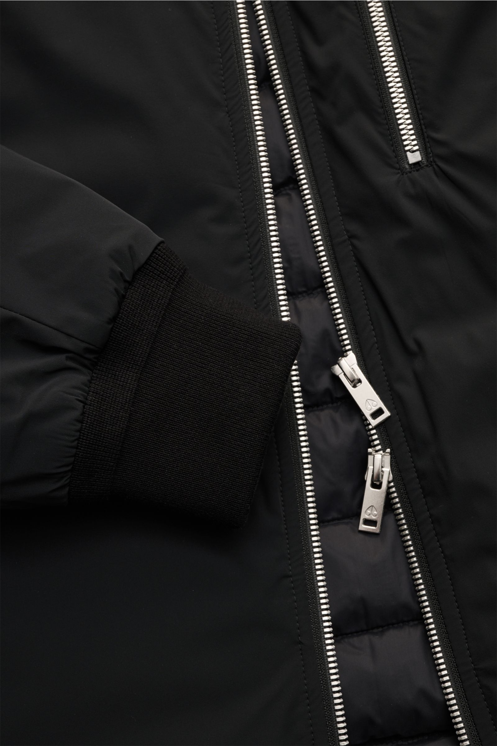 Moose Knuckles Daunenjacke 'Northdale Hoodie' schwarz, Detailansicht von Reißverschluss und Rippbündchen, wind- und wasserabweisend, Slim Fit.
