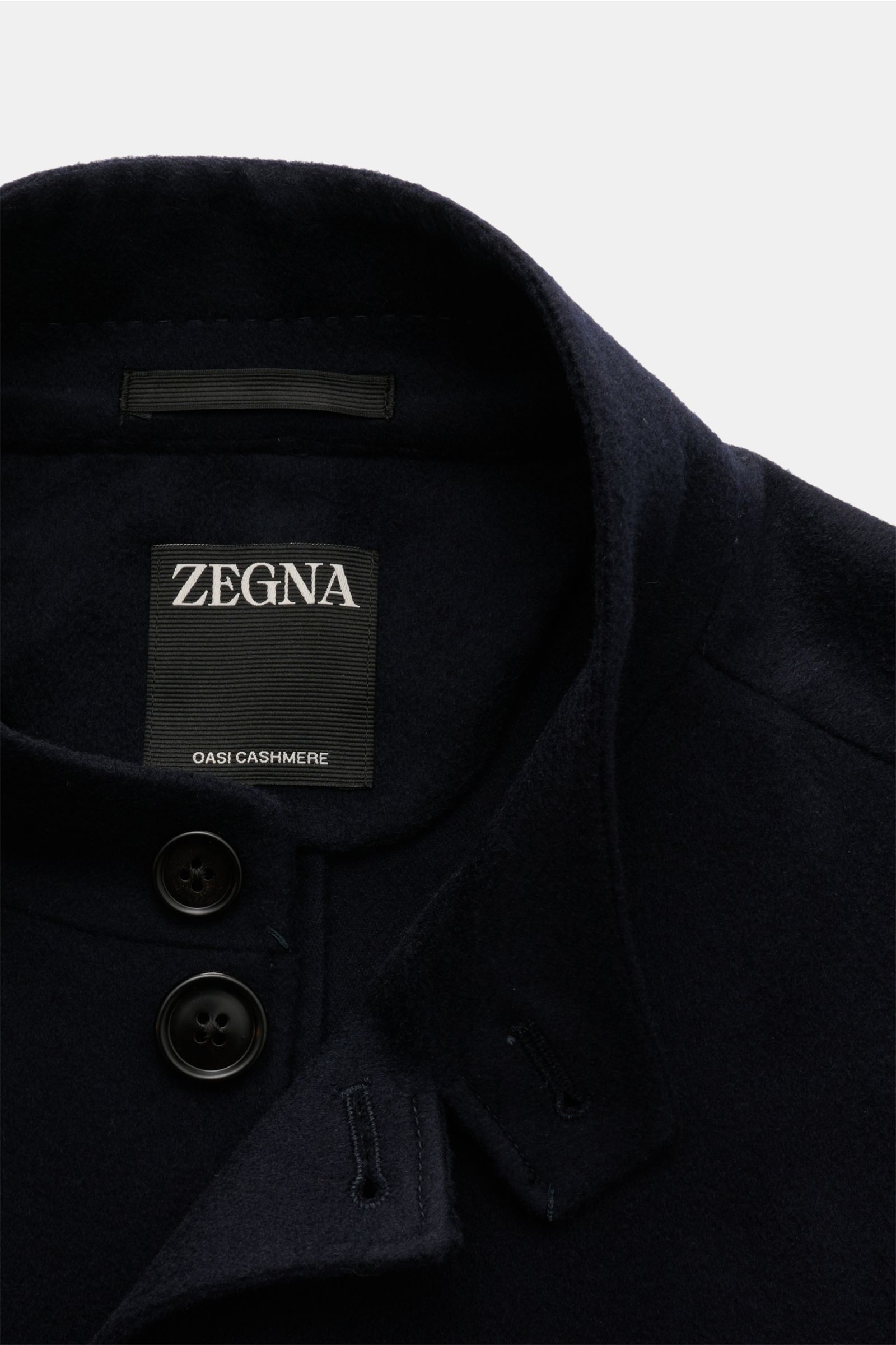 Close-up top view of Zegna Cashmere Jacke navy showing soft cashmere fabric, slim fit design, stand collar with button tab, and four-button placket.

Stilvoll durch die kalte Jahreszeit: Die Cashmere Jacke von ZEGNA umhüllt mit unvergleichlicher Weichh