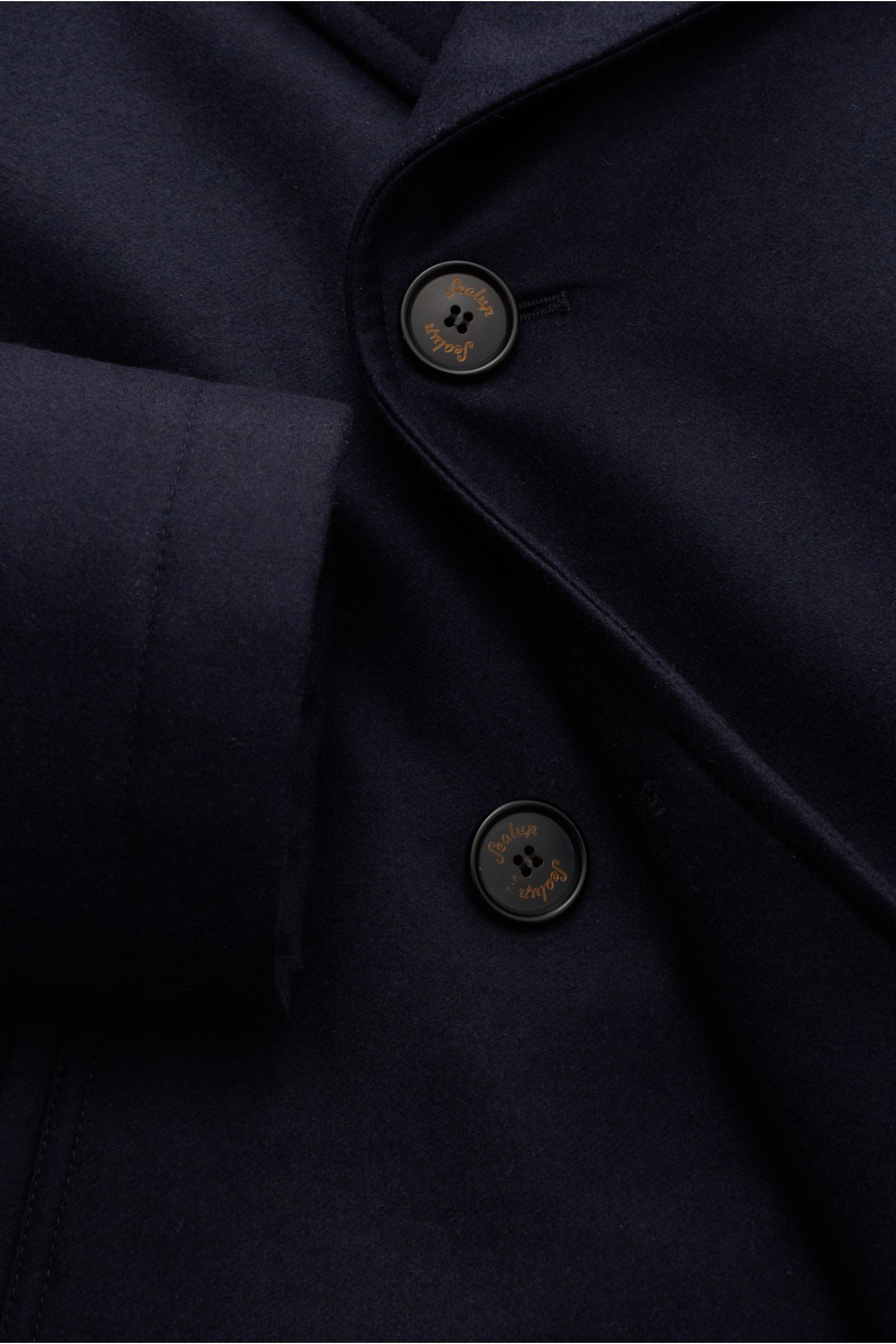Close-up front view of the navy Sealup Pea coat 'Amalfi Graphene Peacoat' showing double-breasted buttons and wool fabric texture.

Description: With the elegant pea coat 'Amalfi Graphene Peacoat' traditional label SEALUP proves that bad weather and elega