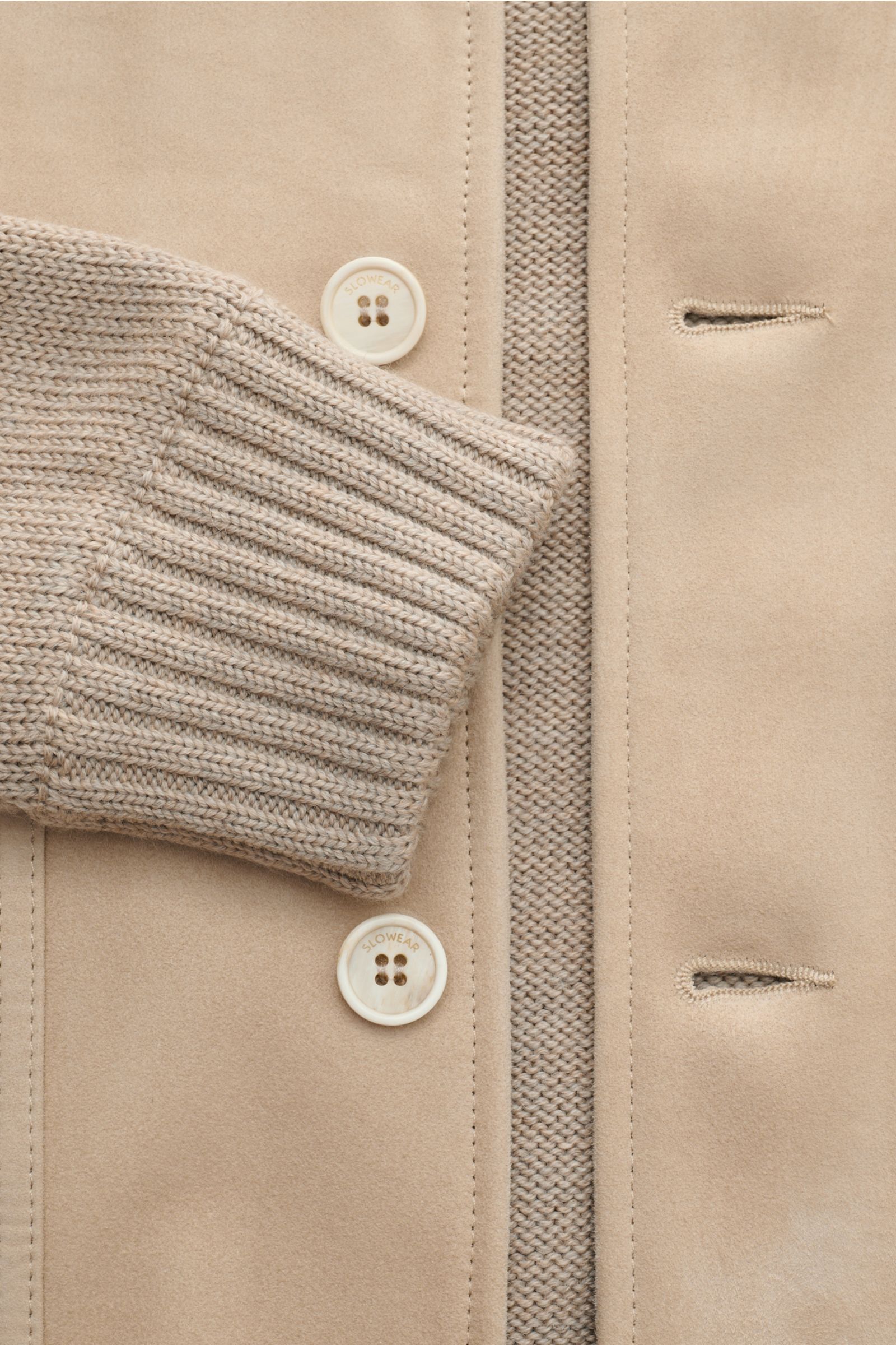 Nahaufnahme des Zanone Strickblouson beige von vorne, zeigt reinen Schurwollstrick, Ziegenveloursleder-Front, Rippkragen, Knöpfe und geknöpfte Pattentasche.