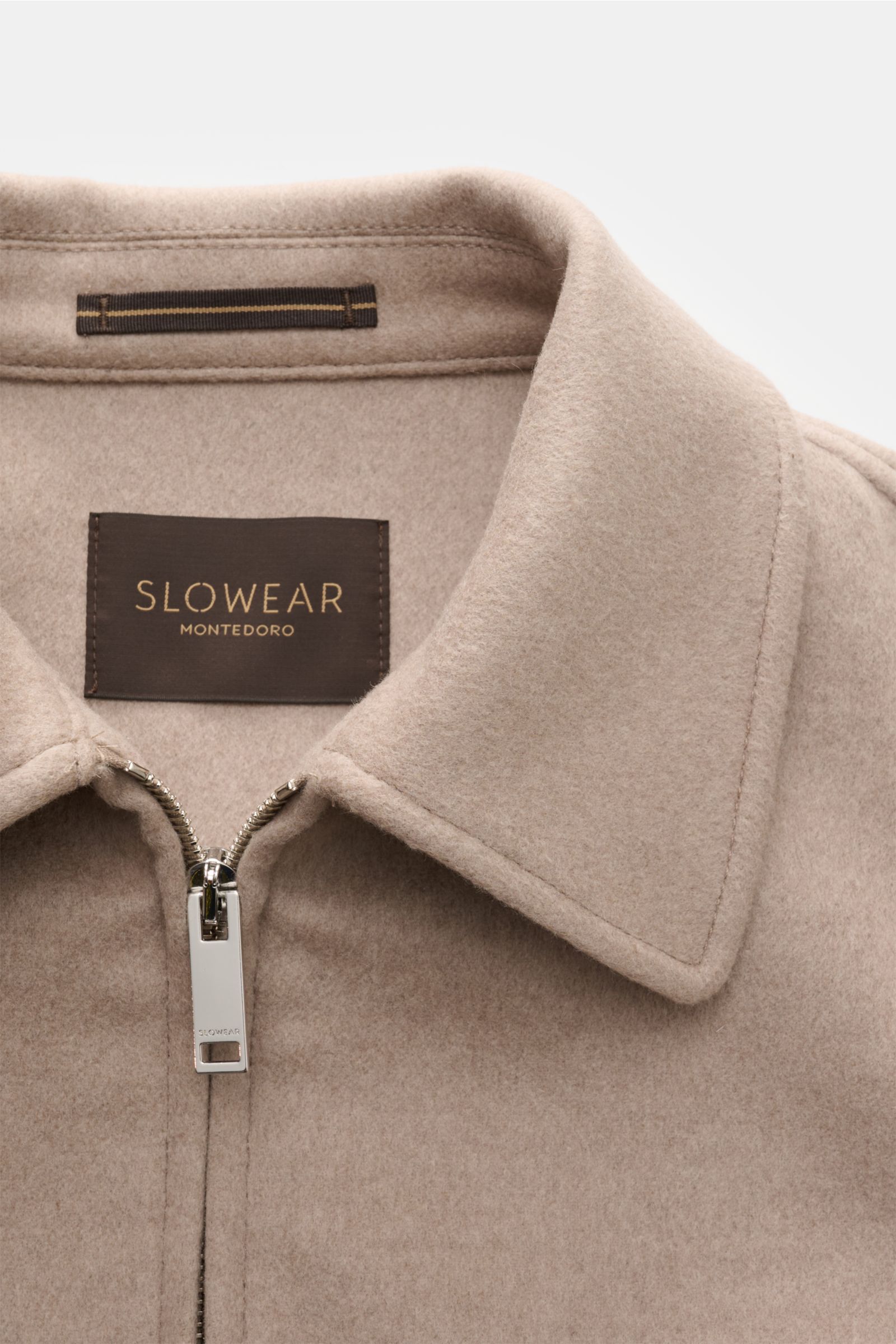 Close-up front view of Montedoro Blouson beige collar and zipper, crafted from soft wool blend for timeless elegance and comfort.