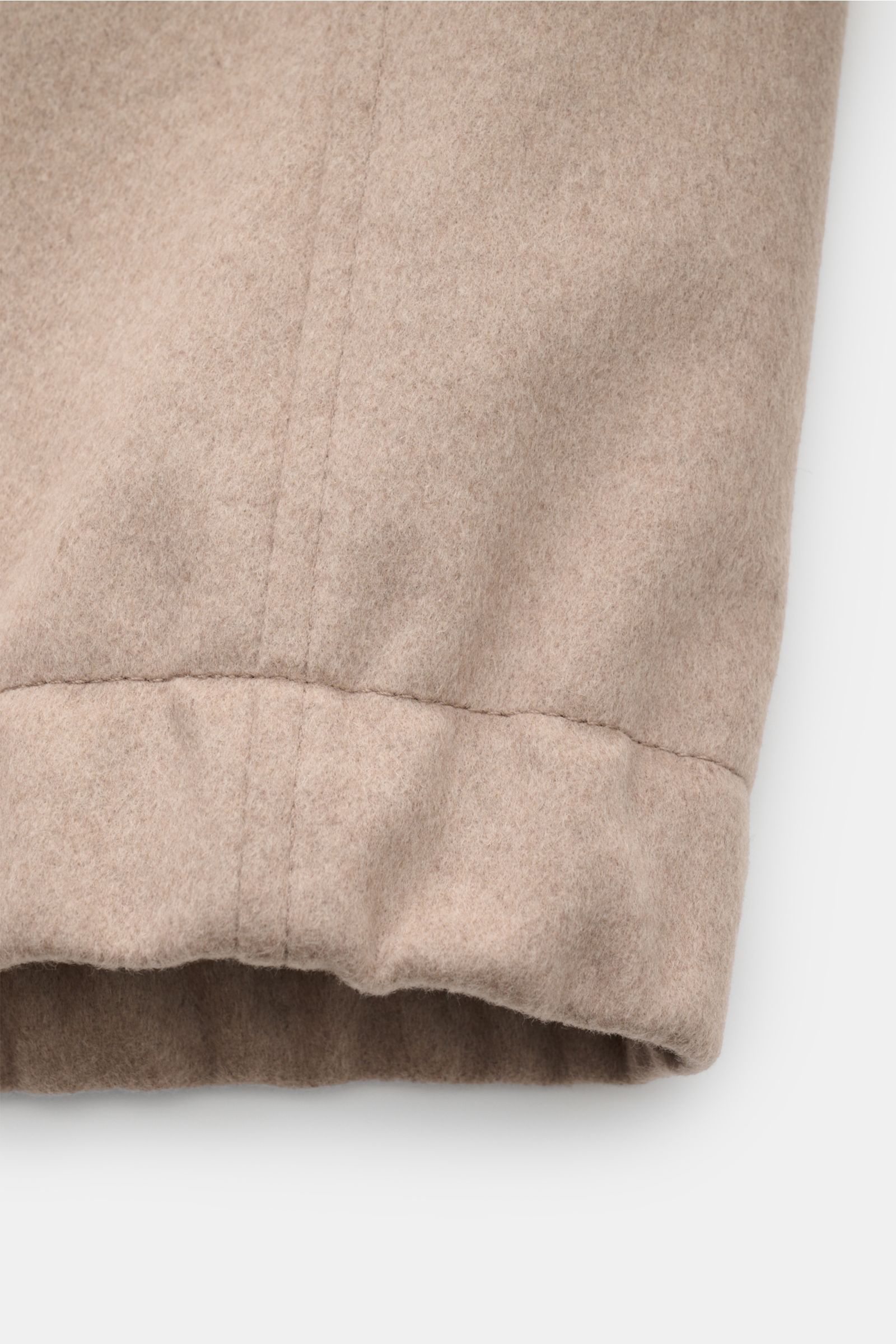 Close-up of the elastic hem of the Montedoro Blouson beige, showing soft wool fabric and fine stitching from a side perspective.

Zeitlose Eleganz trifft höchstem Tragekomfort: Gefertigt aus hochwertiger Schurwolle bietet der Blouson von MONTEDORO ange