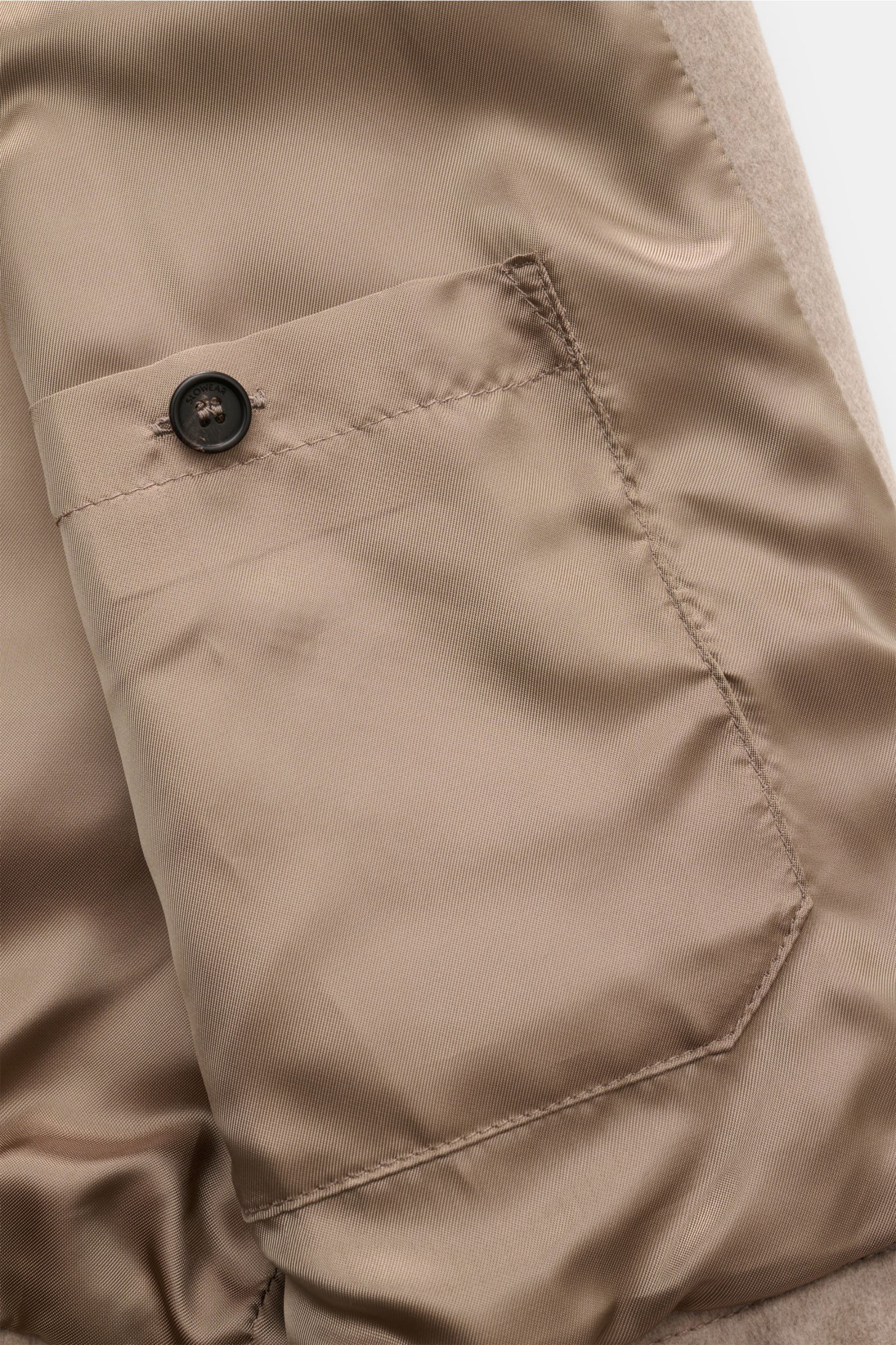 Close-up interior view of the Montedoro Blouson beige showing a smooth, buttoned inner pocket with precise stitching on soft lining.

Description: Zeitlose Eleganz trifft höchstem Tragekomfort: Gefertigt aus hochwertiger Schurwolle bietet der Blouson v