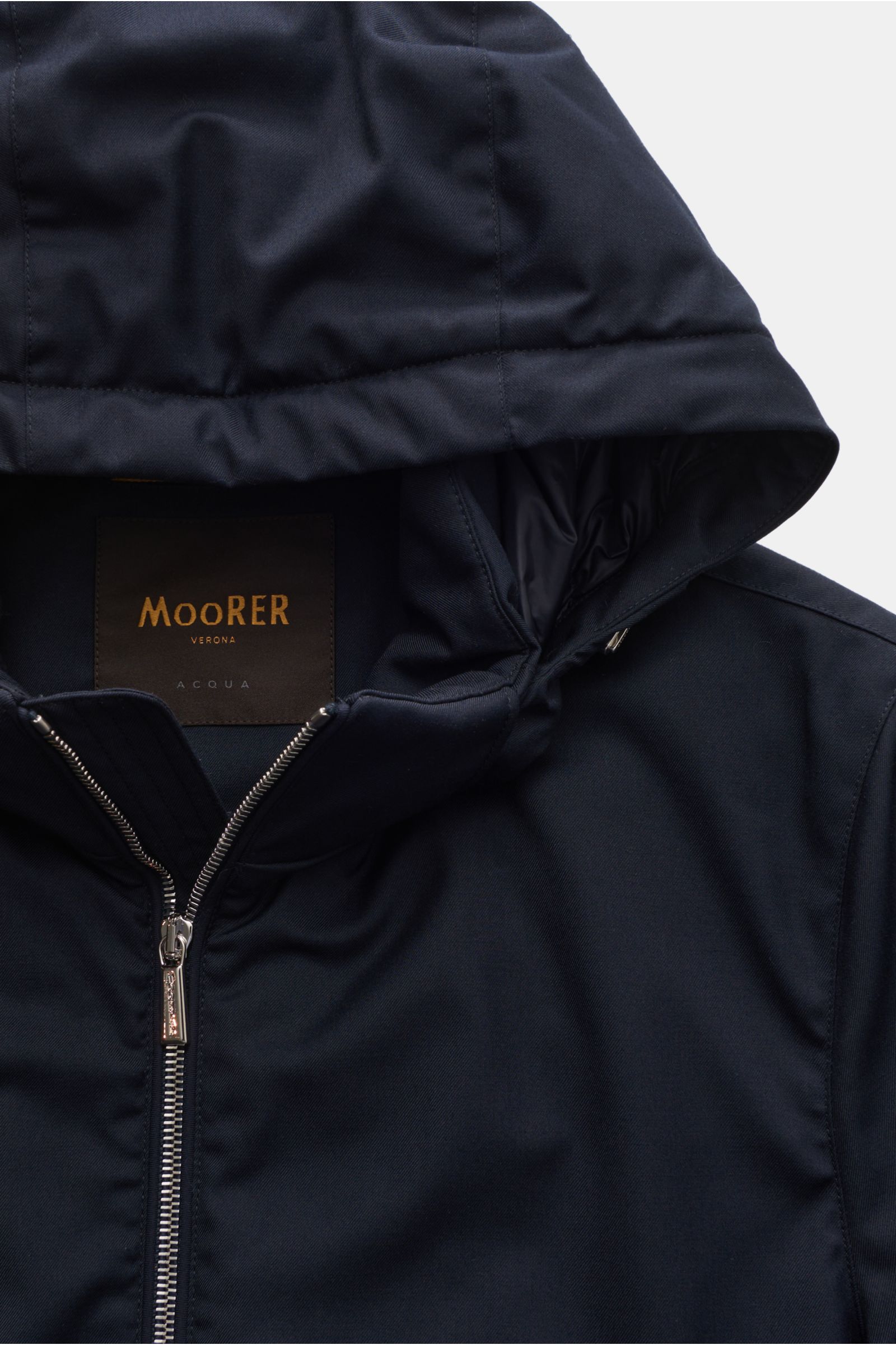 Close-up front top view of Moorer Down jacket 'Albini' navy, showcasing the detachable hood, two-way zip, and high-closing collar.

The short cut, luxurious water repellent jacket 'Albini' with detachable hood by MOORER has a warm yet lightweight down 