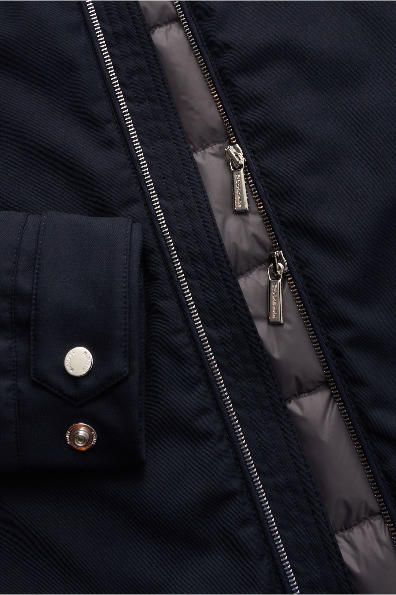Close-up front view of the navy Moorer Down jacket 'Albini' showing the two-way zip, snap button cuff, and quilted warm down lining.

The short cut, luxurious water repellent jacket 'Albini' with detachable hood by MOORER has a warm yet lightweight dow
