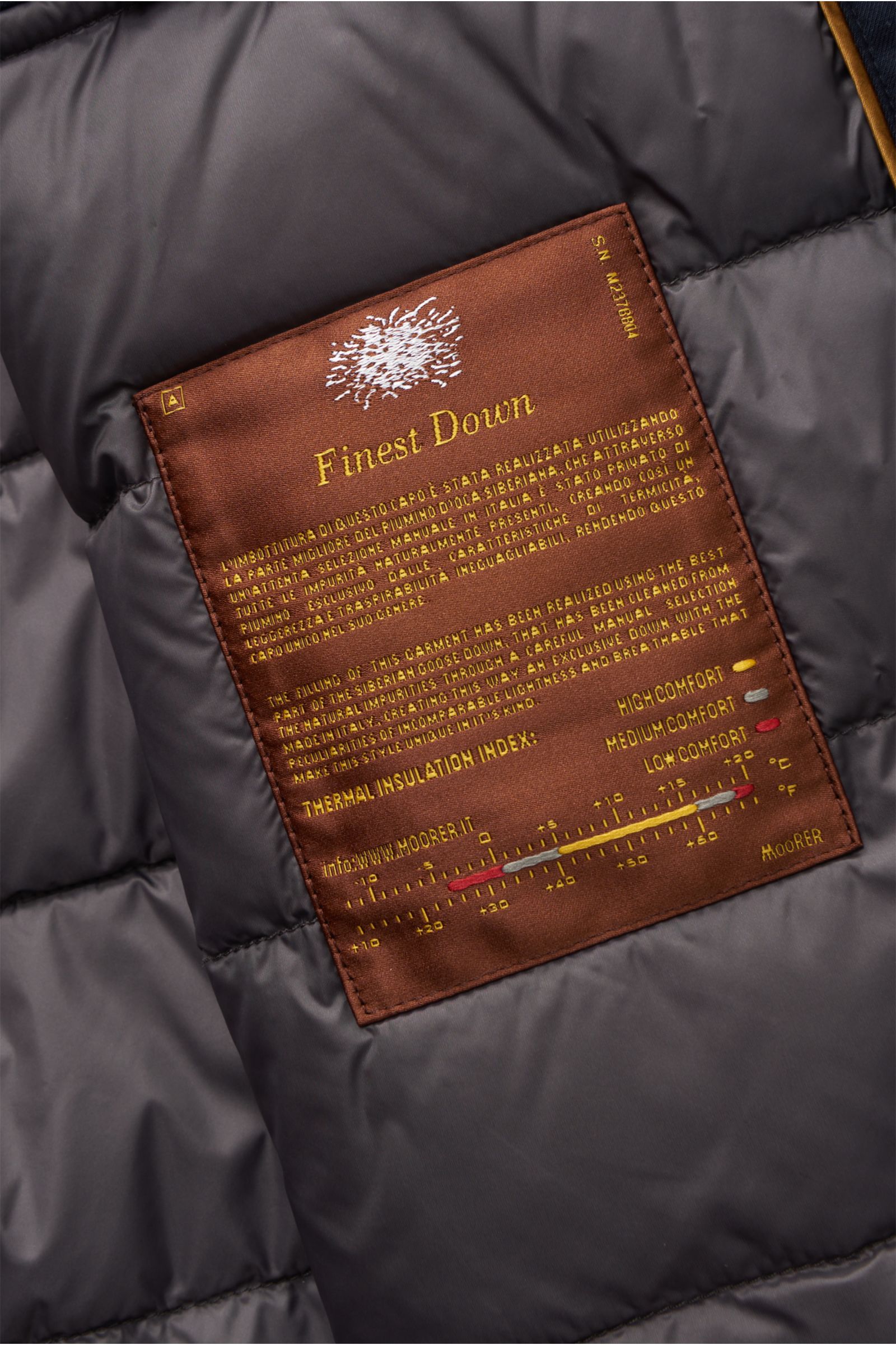 Close-up inside view of the Moorer Down jacket 'Albini' navy showing the brown Finest Down label with thermal insulation details.

The short cut, luxurious water repellent jacket 'Albini' with detachable hood by MOORER has a warm yet lightweight down l